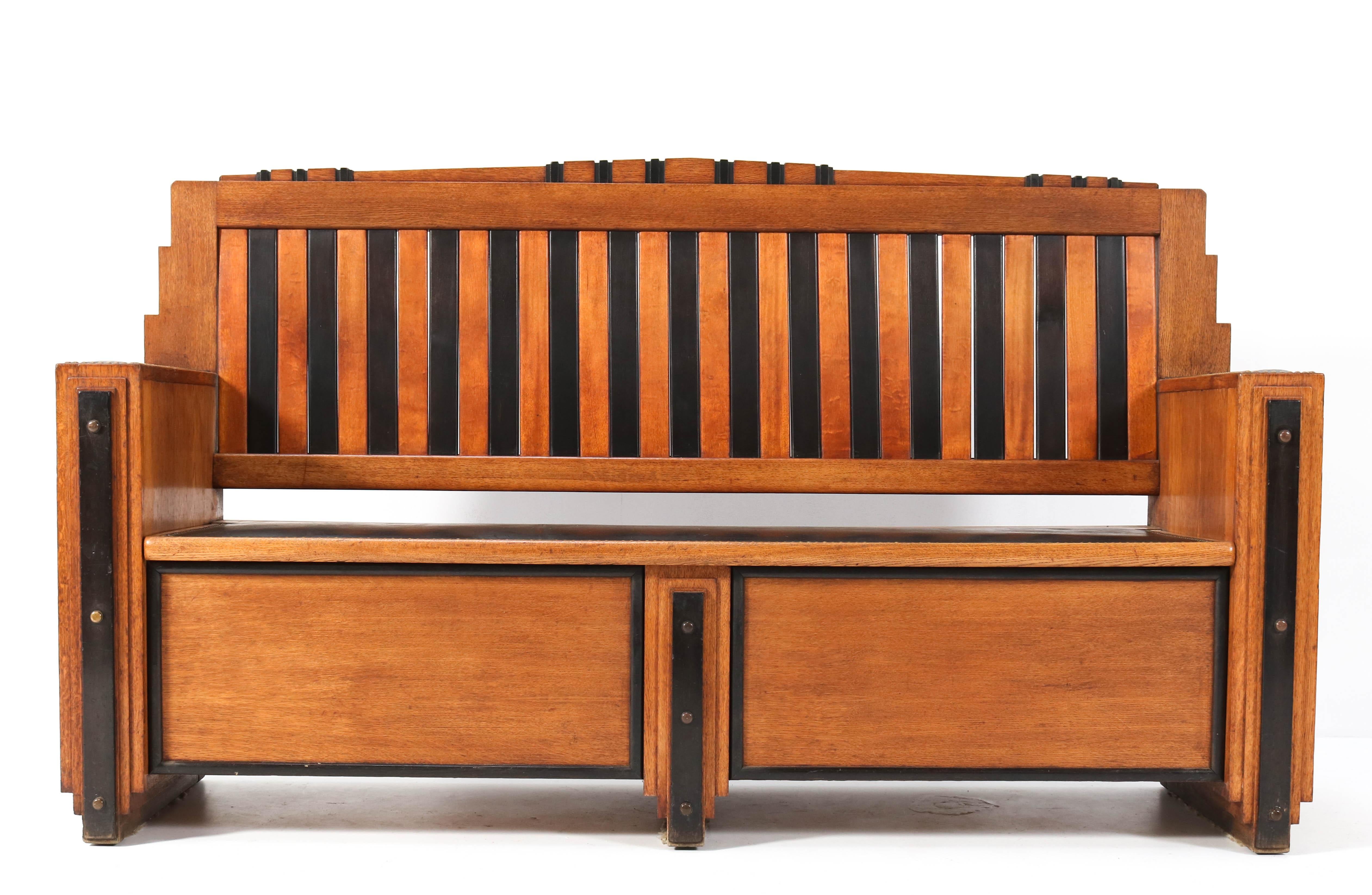 Stunning and rare Art Deco Amsterdam School hall bench.
Striking Dutch design from the 1920s.
Solid oak and oak veneered frame with original black lacquered beech lining.
The seat and the armrests have the original faux leather upholstery.
This
