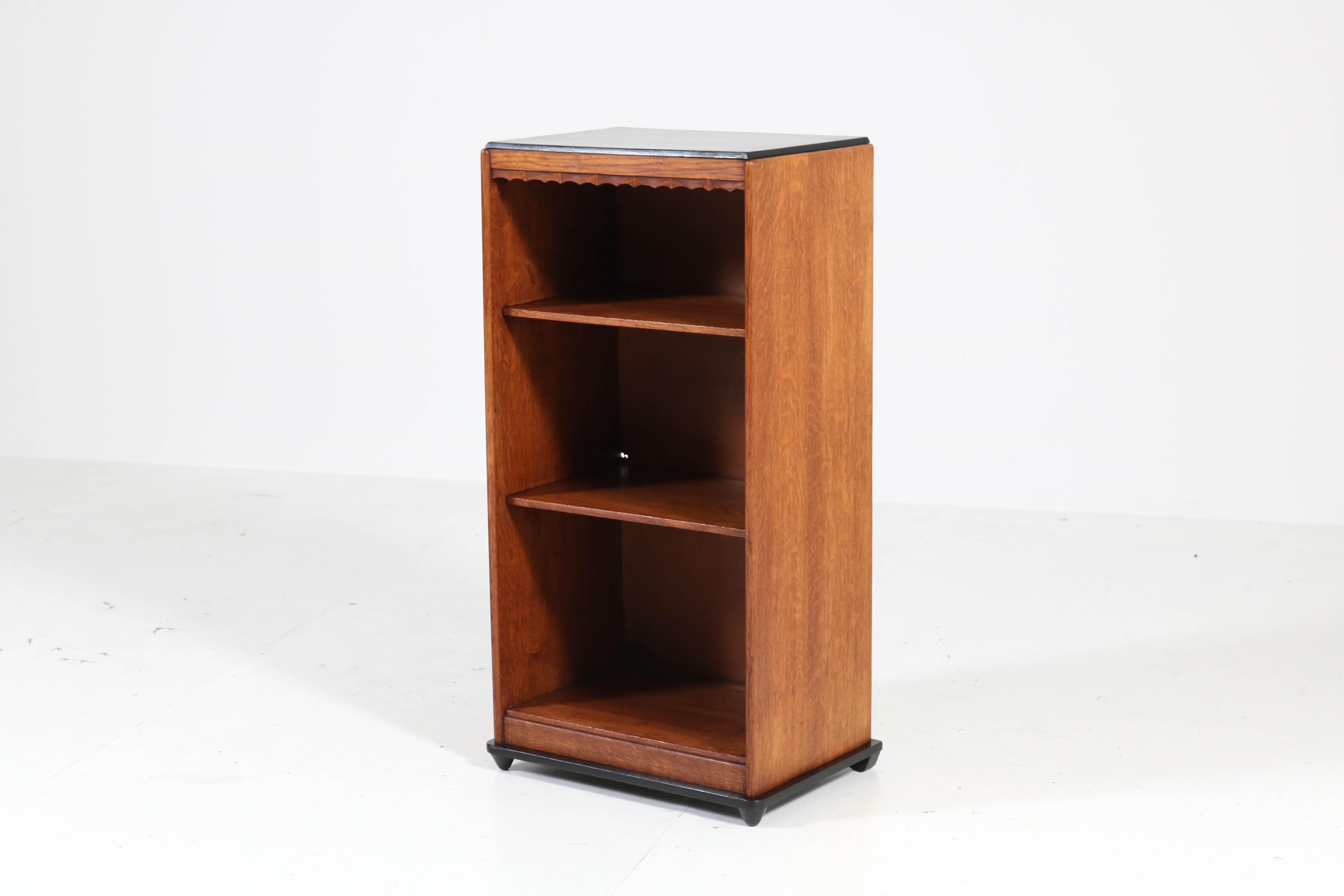 Elegant and rare Art Deco Amsterdam School open bookcase.
Design by Willem Penaat for Metz & Co., Amsterdam.
Striking Dutch design from the 1920s.
Solid oak with original black lacquered top.
In very good condition with minor wear consistent