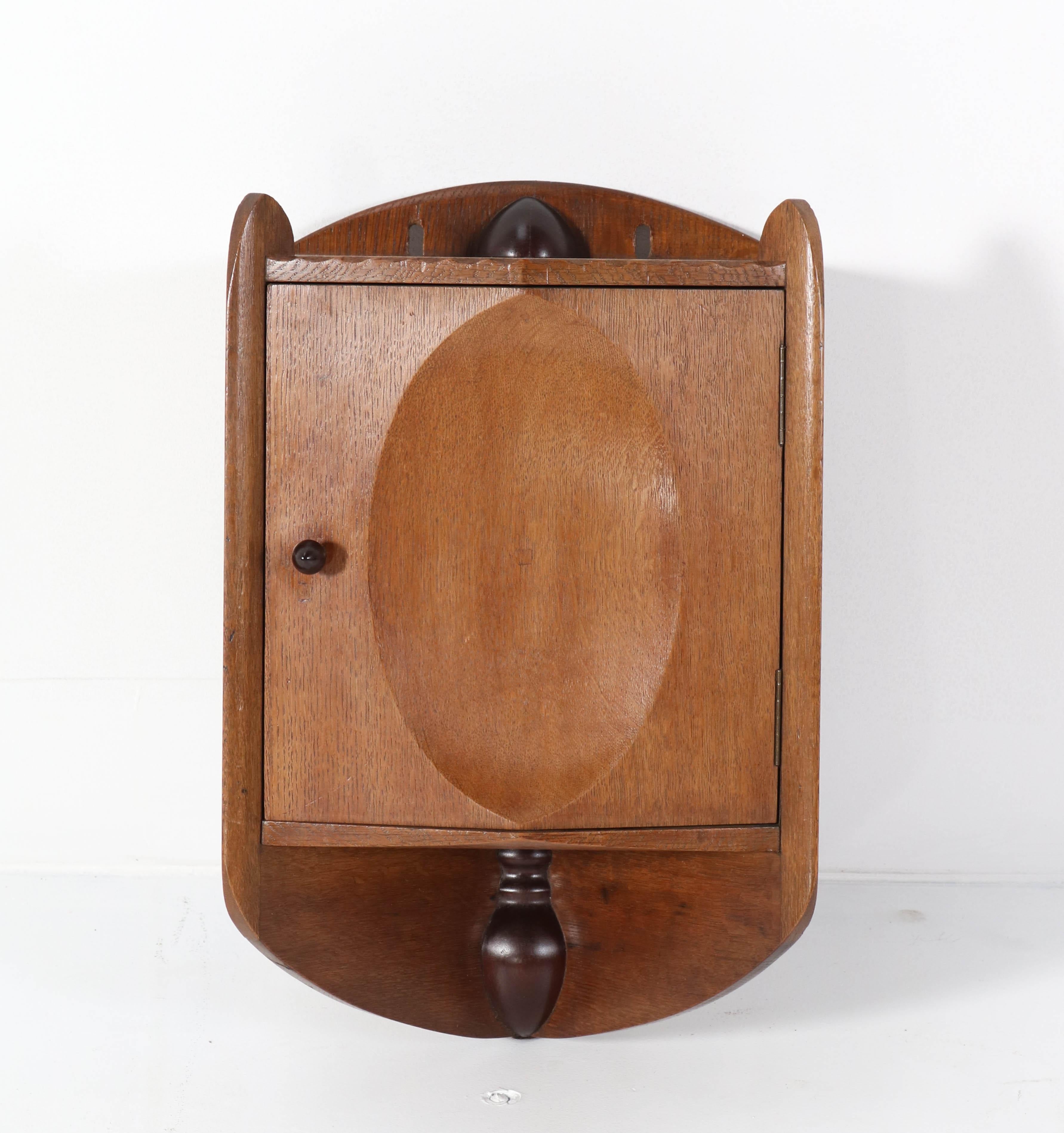 Magnificent and very rare Art Deco Amsterdam School wall cabinet.
Design by Louis Deen.
Striking Dutch design from the 1920s.
This wonderful shaped piece of furniture is made out of solid oak with
solid mahogany decoration.
In very good
