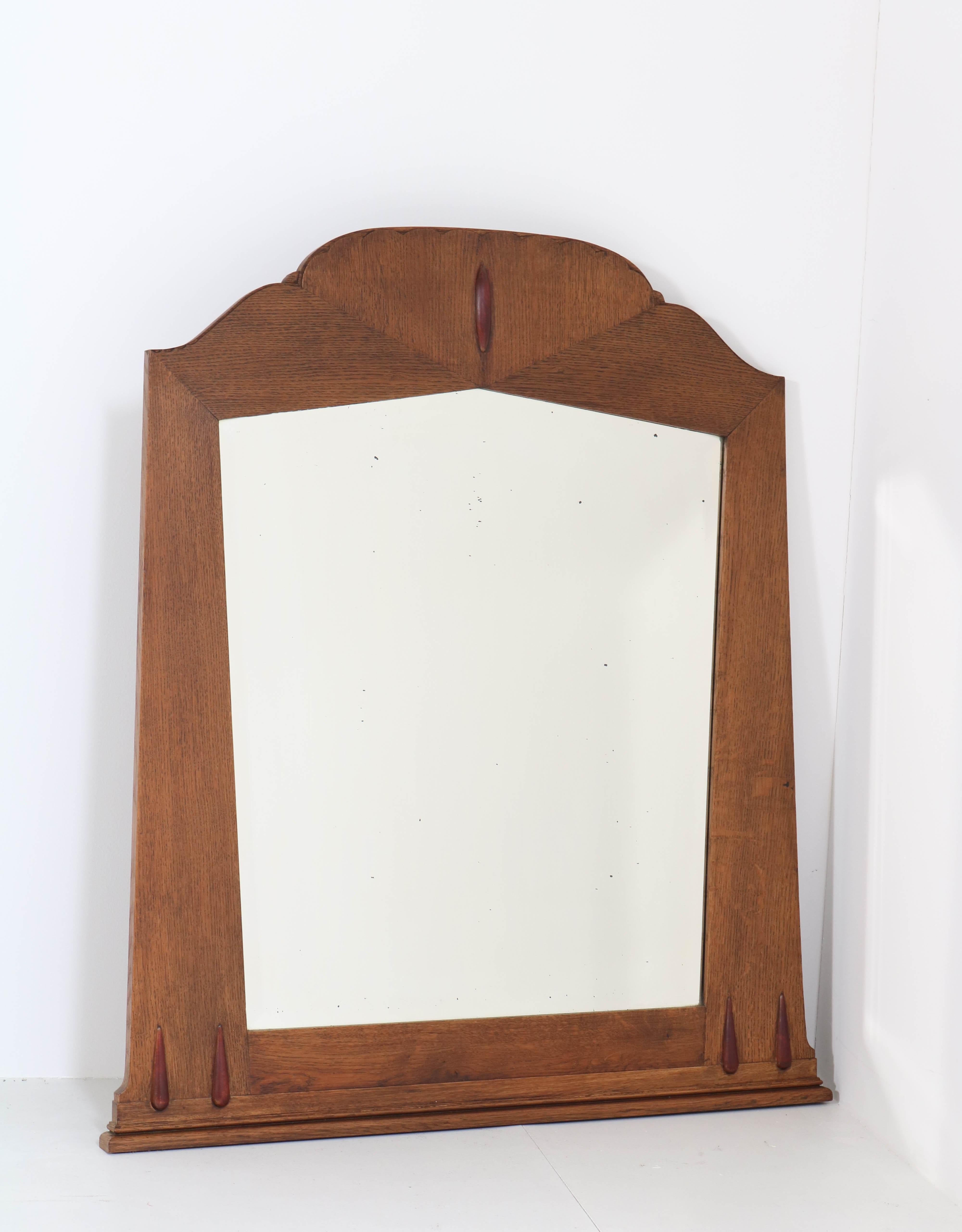 Stunning and rare Art Deco Amsterdam School wall mirror.
Design by Fa. S. Speelman Rotterdam.
Striking Dutch design from the twenties.
Solid oak frame with original beveled mirrored glass.
In very good original condition with minor wear (the