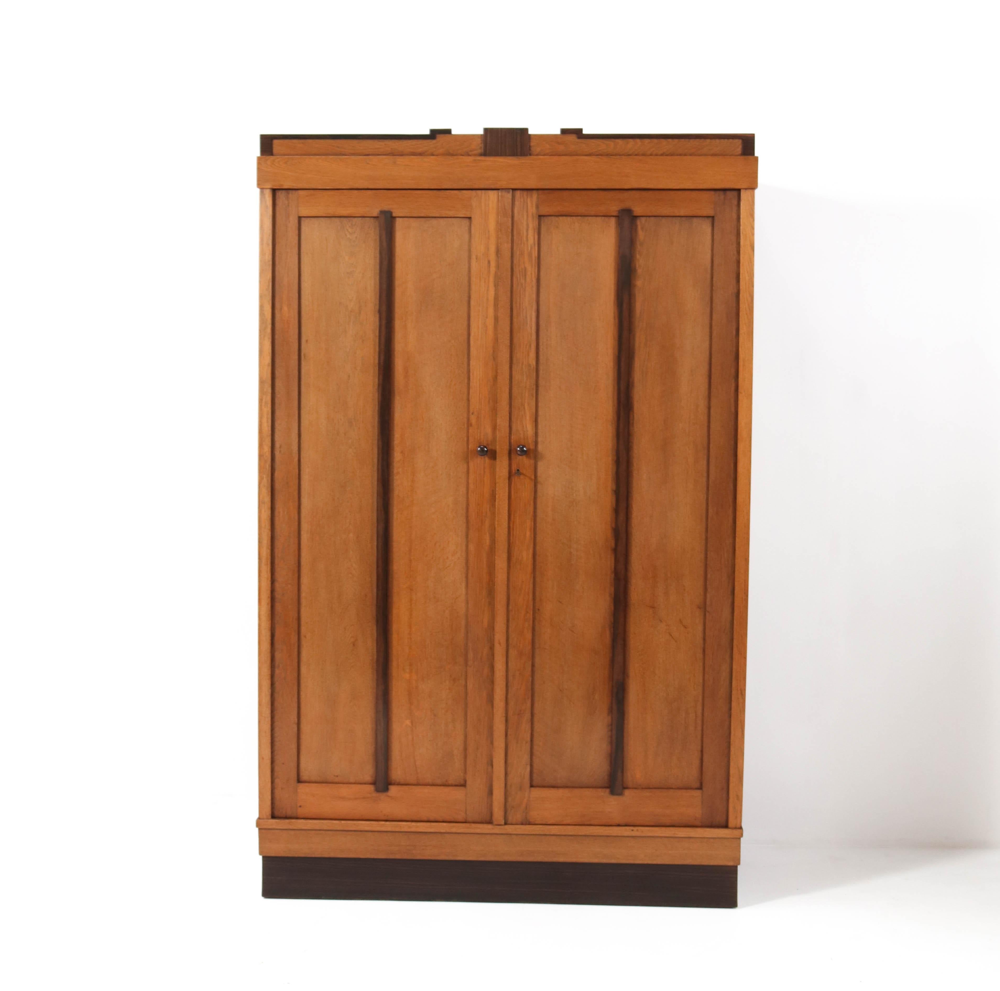 Stunning and rare Art Deco Amsterdamse School armoire or wardrobe.
Striking Dutch design from the 1920s.
Solid oak with original macassar ebony details.
Four wooden shelves adjustable in height or in case you do not need shelves,
we can put in a