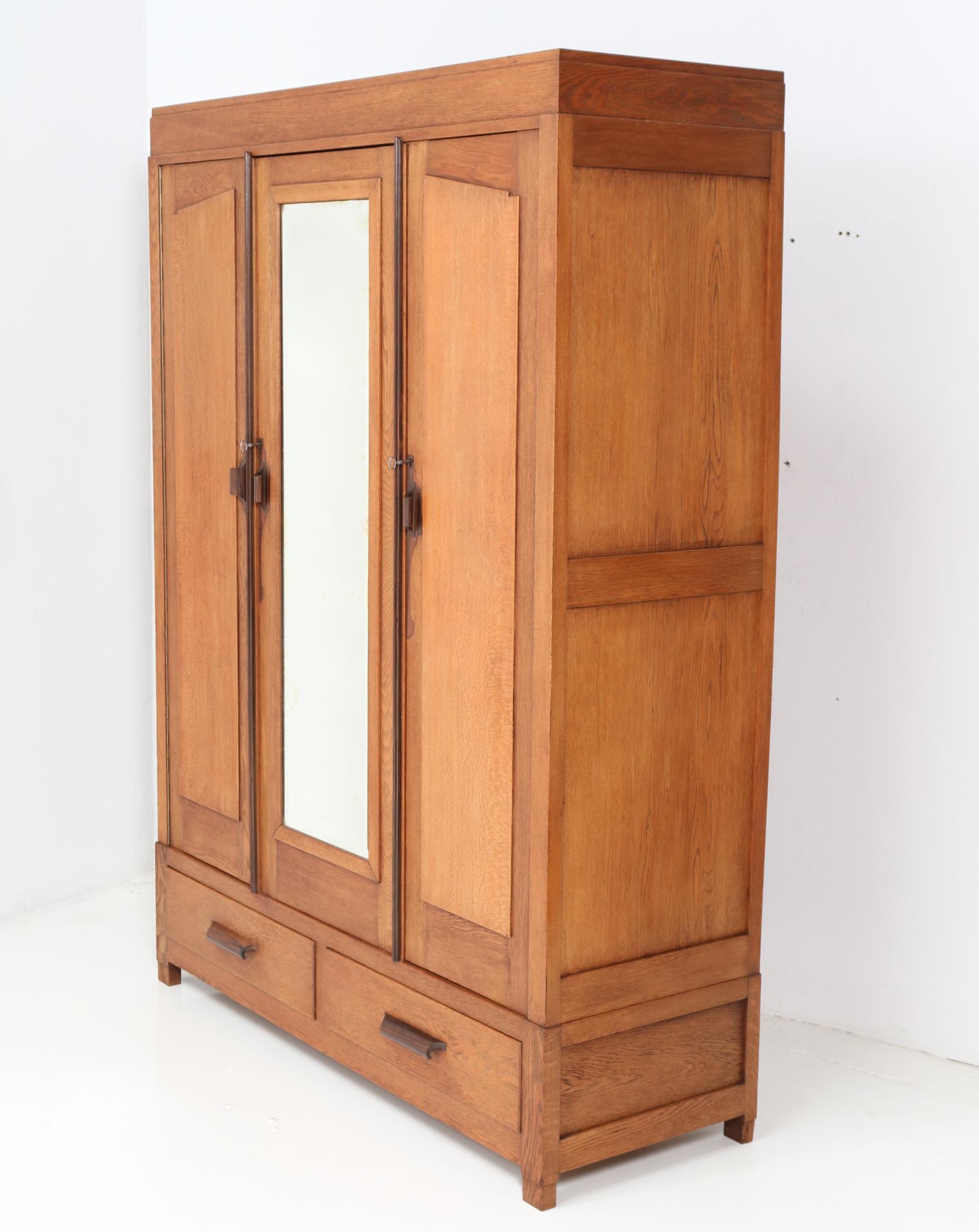 Stunning and rare Art Deco Amsterdamse School armoire or wardrobe.
Striking Dutch design from the 1920s.
Solid oak and original oak veneer base with original solid macassar handles.
The left door and the right door are made out of solid oak with