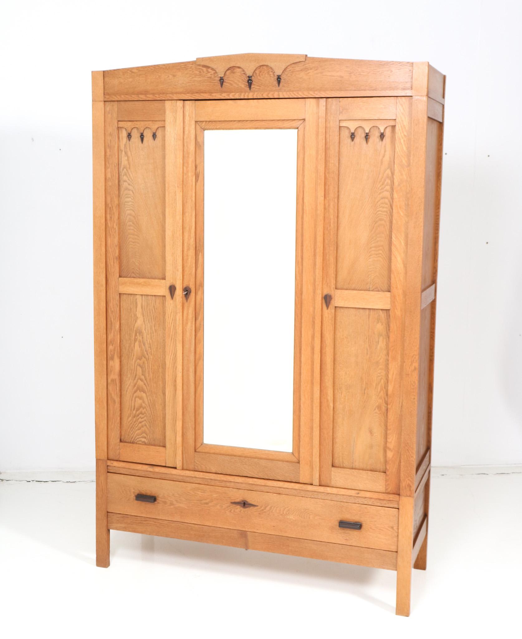 Stunning and rare Art Deco Amsterdamse School armoire or wardrobe.
Striking Dutch design from the 1920s.
Solid oak and original oak veneer and solid macassar ebony elements.
The drawer has solid macassar ebony handles.
In very good original