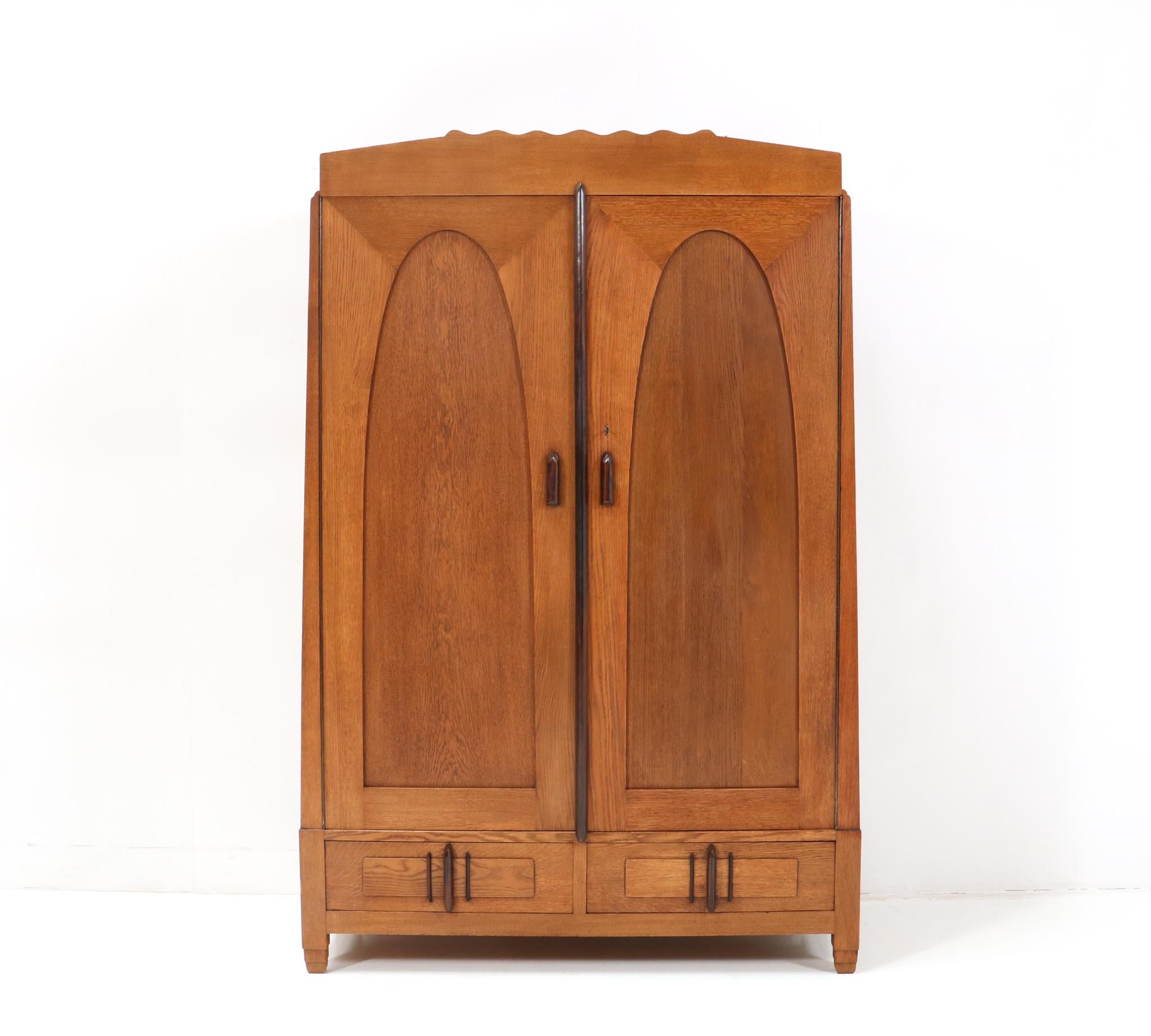 Magnificent and rare Art Deco Amsterdamse School armoire or wardrobe.
Design by J.J. Zijfers Amsterdam.
Striking Dutch design from the 1920s.
Solid oak with original solid macassar ebony elements.
Behind the left door you will find three