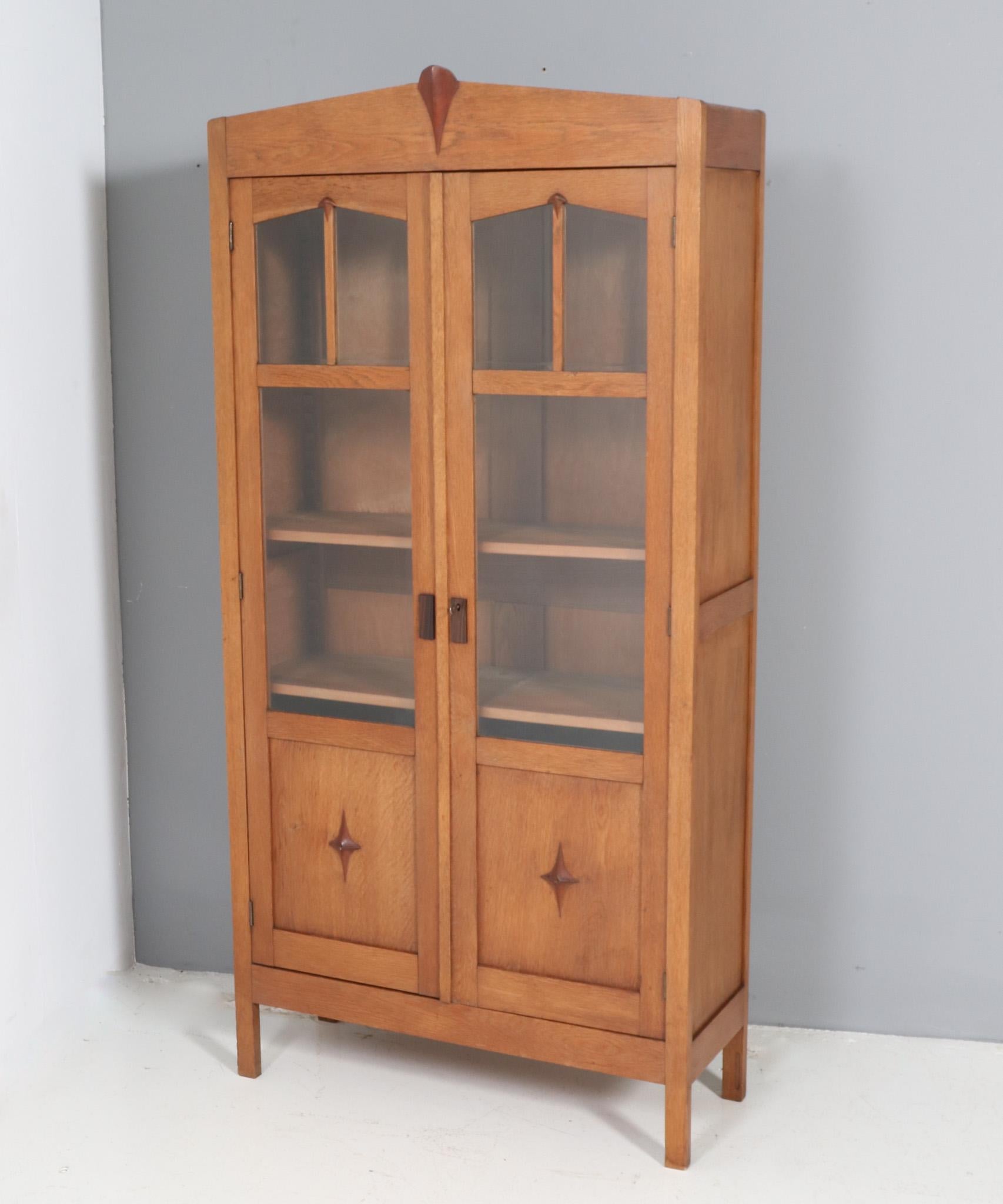Stunning and rare Art Deco Amsterdamse School bookcase.
Striking Dutch design from the 1920s.
Solid oak and original oak veneer base with original solid padouk decorative elements.
Original small beveled glass panels and original larger plain glass