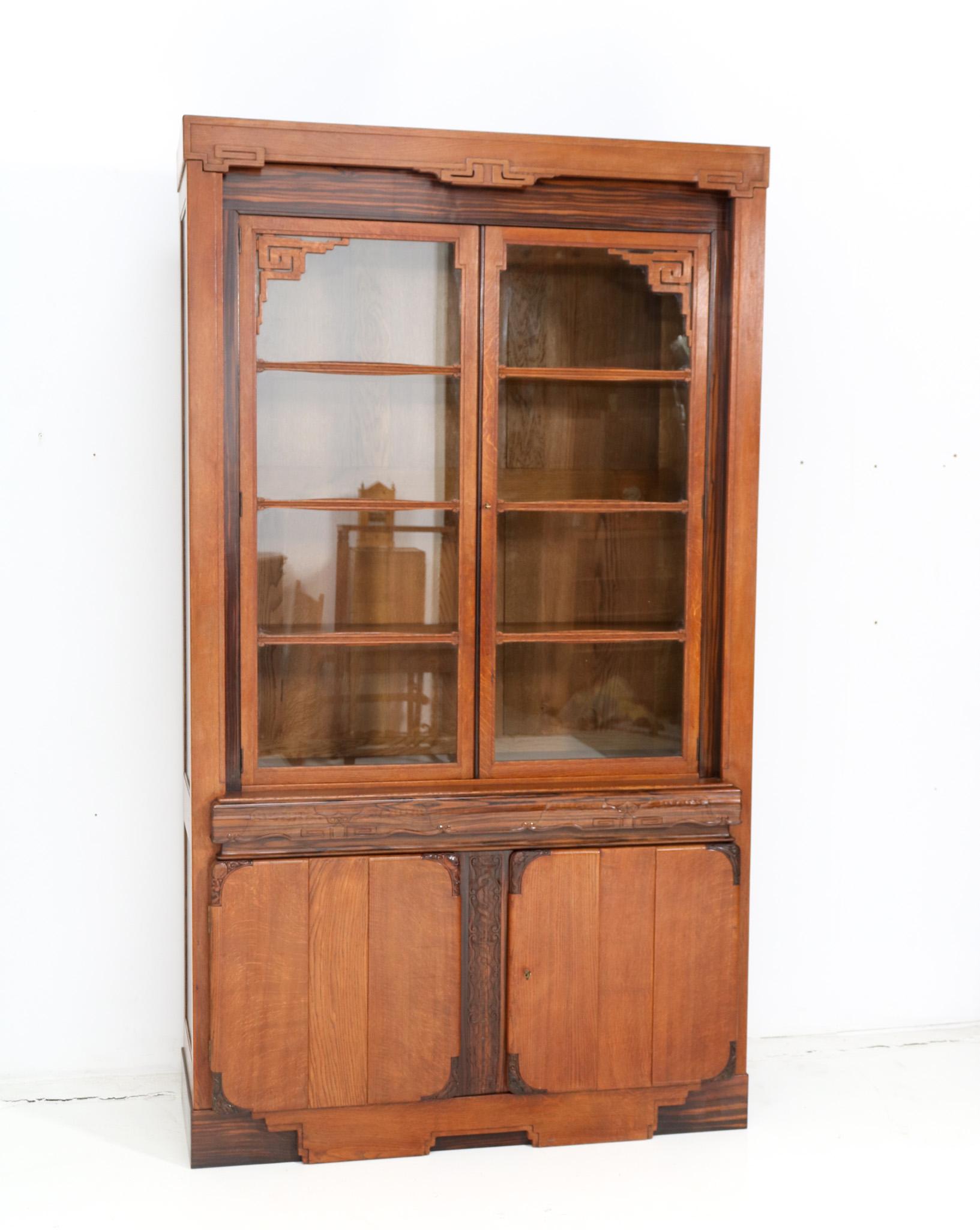 Magnificent and ultra rare Art Deco Amsterdamse School bookcase or vitrine.
Design by Napoleon le Grand for 't Modelhuis N. Le Grand Amsterdam.
Striking Dutch design from the 1920s.
Solid oak base with original hand carved decorative solid