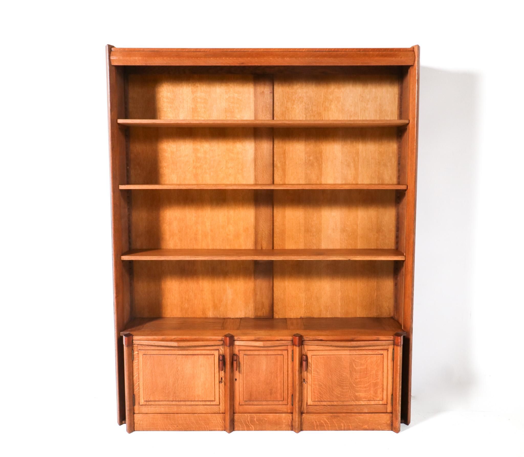 Magnificent and ultra rare Art Deco Amsterdamse School bookcase.
Design by Willem Retera and executed by Fa. Wed. Ingenhoes Amsterdam.
Solid oak frame with three original doors and three hand-carved padouk handles.
Three original solid oak shelves,