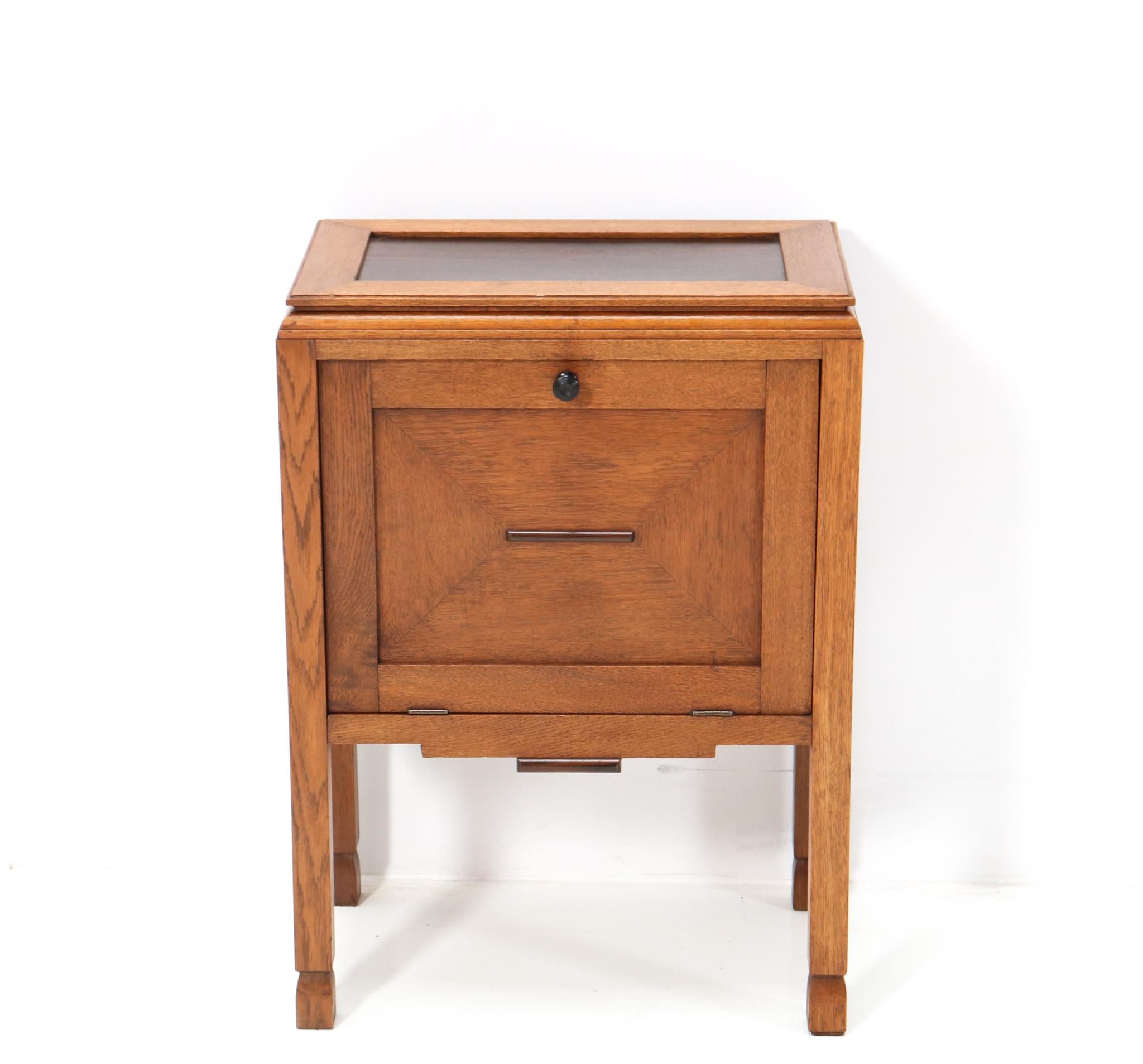 Magnificent and ultra rare Art Deco Amsterdamse School cabinet.
Striking Dutch design from the 1920s.
Solid oak with original oak veneer base with original macassar ebony knob and
elements.
The top is original and veneered with macassar ebony
