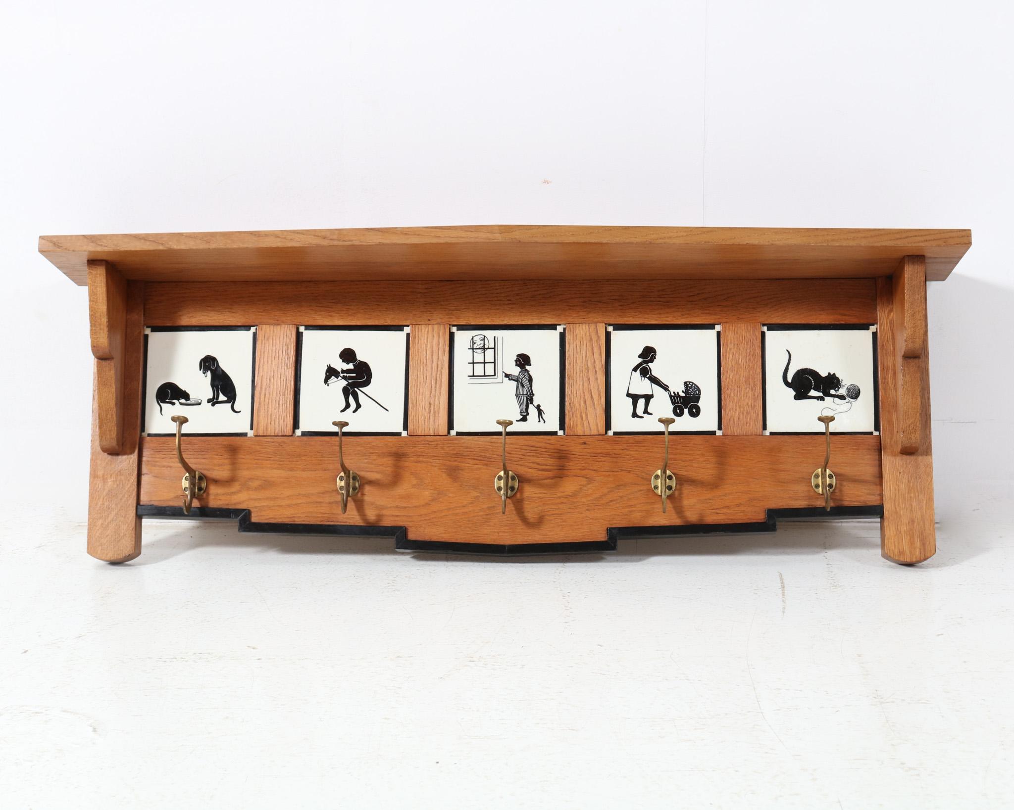 Stunning and ultra rare Art Deco Amsterdamse School coat rack.
Striking Dutch design from the 1920s.
Solid oak and black lacquered frame with five original ceramic tiles.
All tiles have decorative images such as a cat playing with a ball of wool and