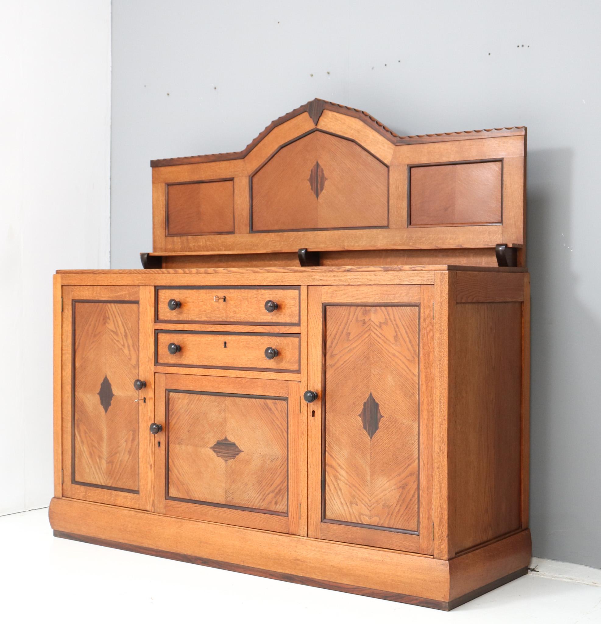 Stunning and rare Art Deco Amsterdamse School credenza or sideboard.
Design by Fa. Drilling Amsterdam.
Striking Dutch design from the 1920s.
Solid oak and macassar ebony base with solid macassar ebony knobs on doors and drawers.
The doors are