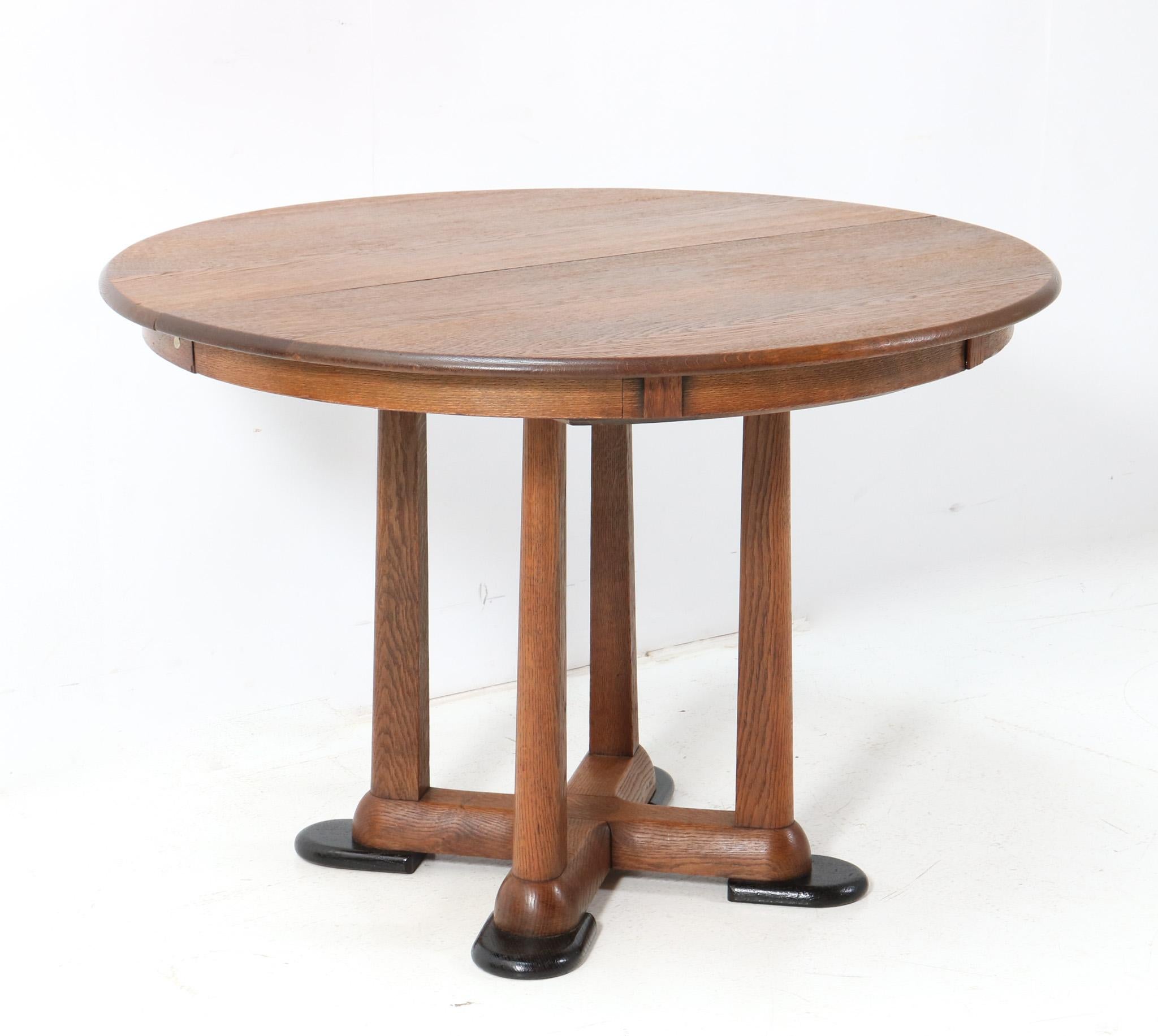 Magnificent and ultra rare Art Deco  Amsterdamse School extendable dining room table.
Design by A.F. van der Weij for L.O.V. Oosterbeek.
Striking Dutch design from the 1920s.
Solid oak base with black lacquered feet.
The round top can be transformed