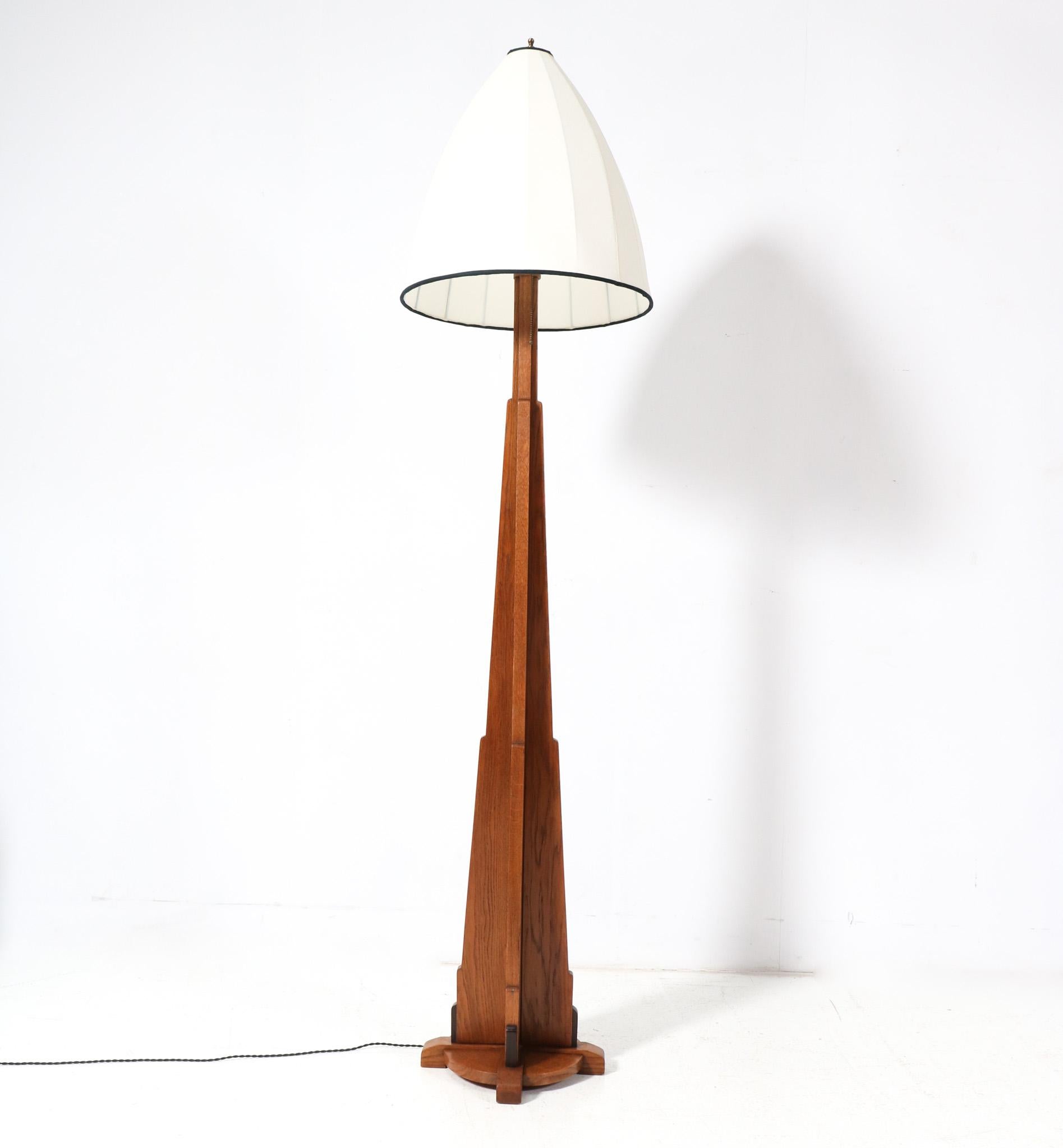 Magnificent and rare Art Deco Amsterdamse School floor lamp.
Striking Dutch design from the 1920s
Solid oak base with solid macassar ebony decorative elements.
The original shade has been re-upholstered with a yellow Shantung silk and the inside