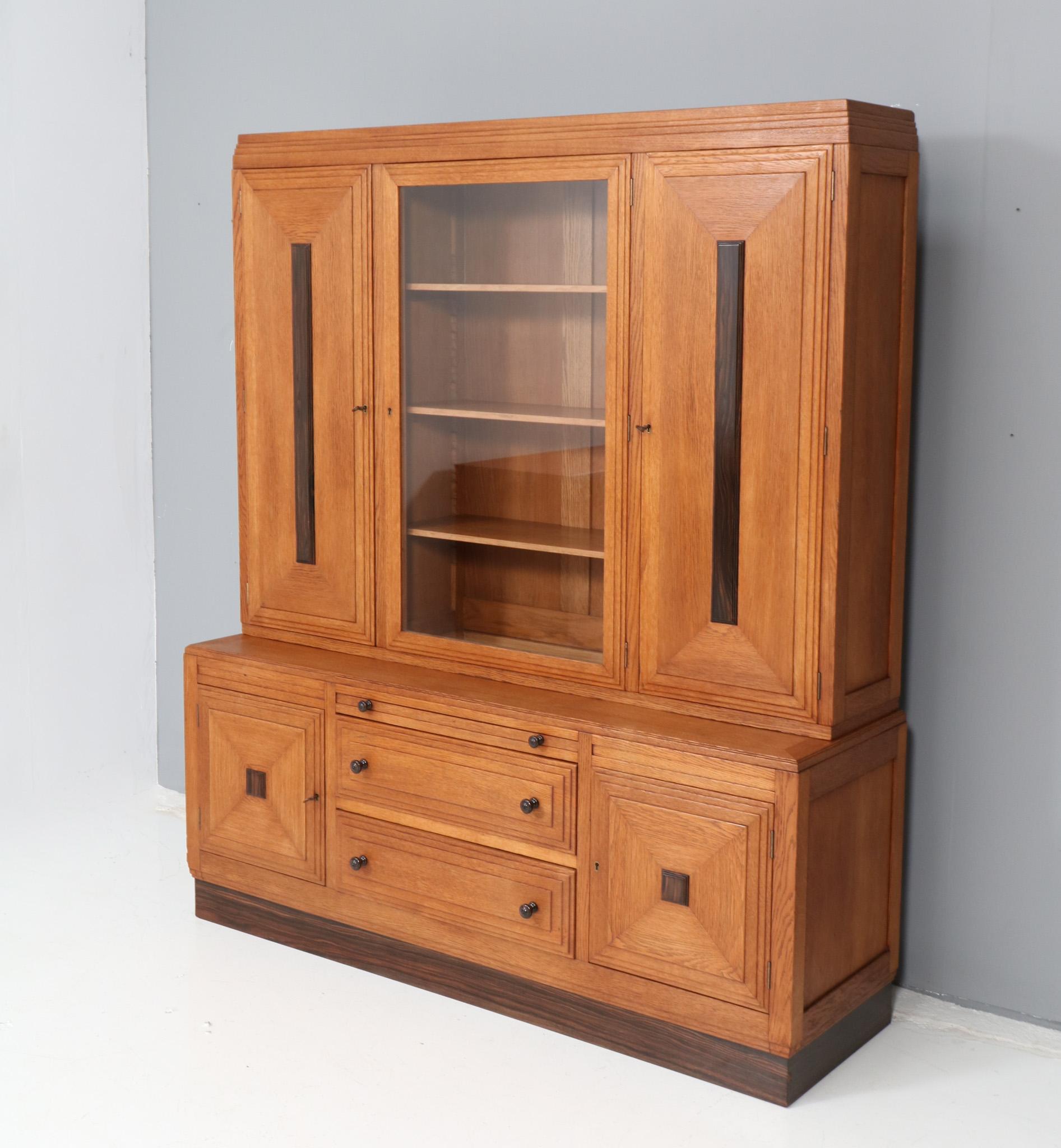 Magnificent and ultra rare Art Deco Amsterdamse School two-piece bookcase.
Design attributed to Piet Kramer for N.V. v/h A.M. Randoe en Zonen Haarlem.
Striking Dutch design from the 1920s.
Solid oak base with original solid macassar ebony knobs on
