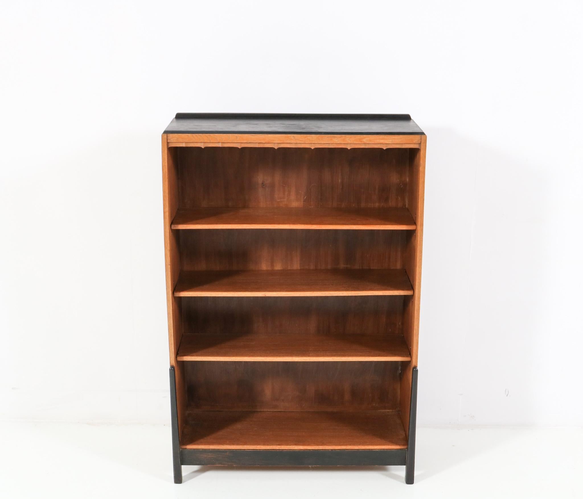 Magnificent and ultra rare Art Deco Amsterdamse School open bookcase.
Design by Willem Penaat for Metz & Co. Amsterdam.
Striking Dutch design from the 1920s.
Solid oak with original black lacquered top and front legs.
Three original solid oak