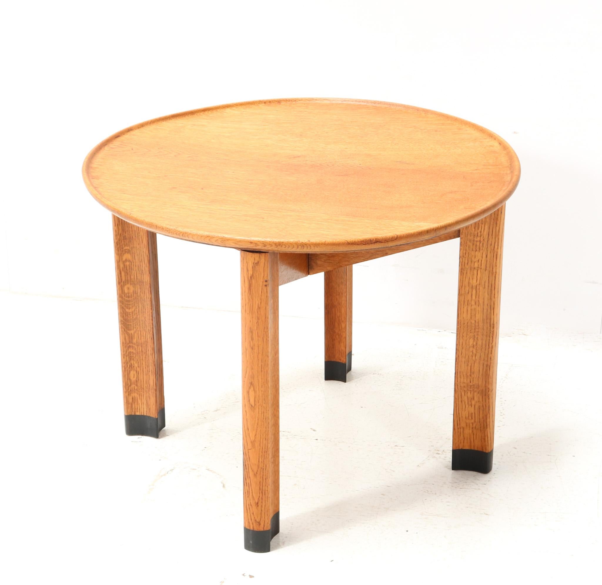 Magnificent and rare Art Deco Amsterdamse School side table.
Design by Piet Kramer for N.V. v/h A.M. Randoe en Zonen Haarlem.
Solid oak frame with at the end of the four legs black lacquered socks.
Original solid oak top.
The sleek and elegant