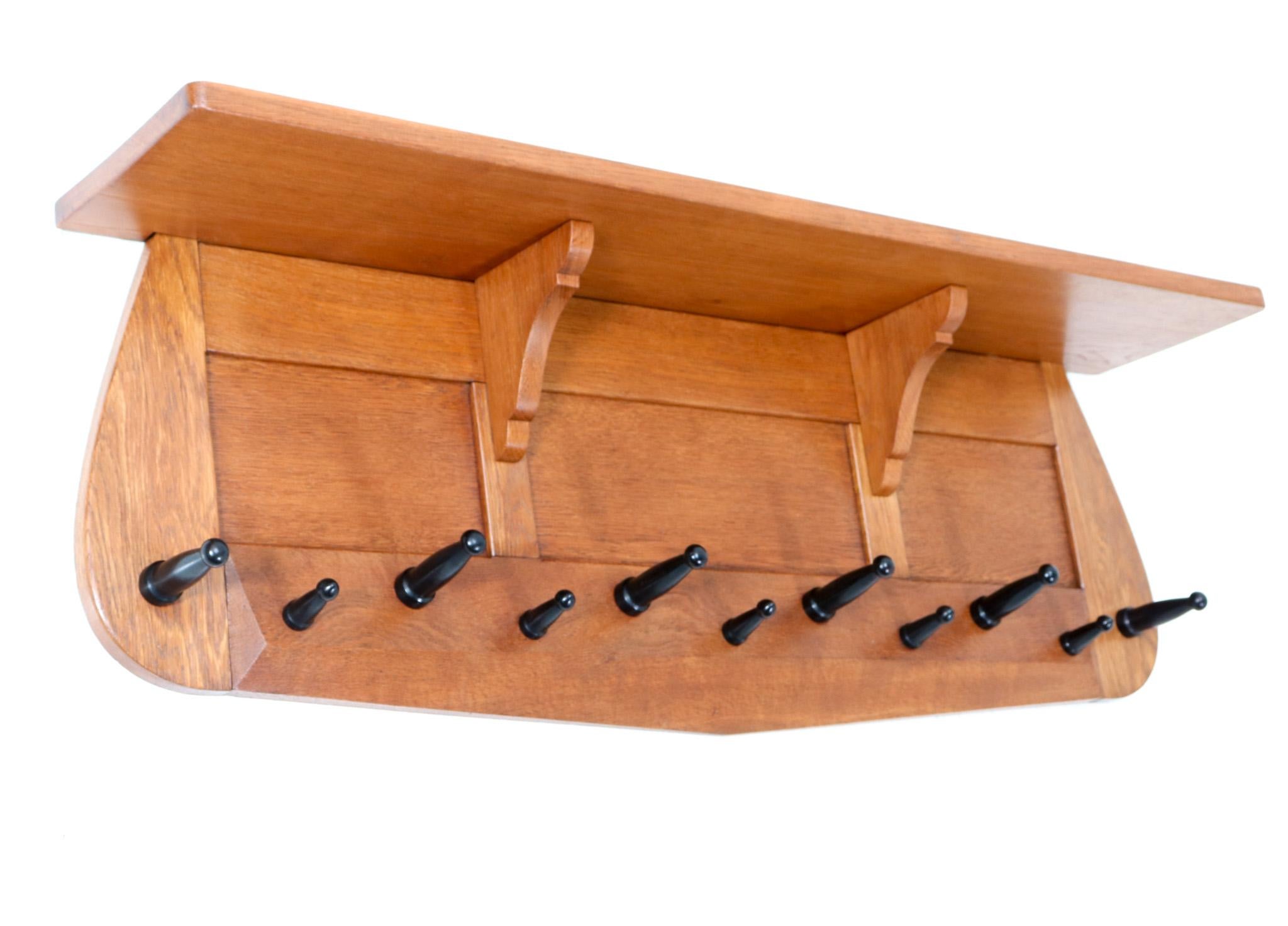 Stunning and rare Art Deco Amsterdamse School wall coat rack.
Design in the style of Paul Bromberg.
Striking Dutch design from the 1920s.
Solid oak frame with eleven original black lacquered wooden hooks.
This wonderful Art Deco Amsterdamse