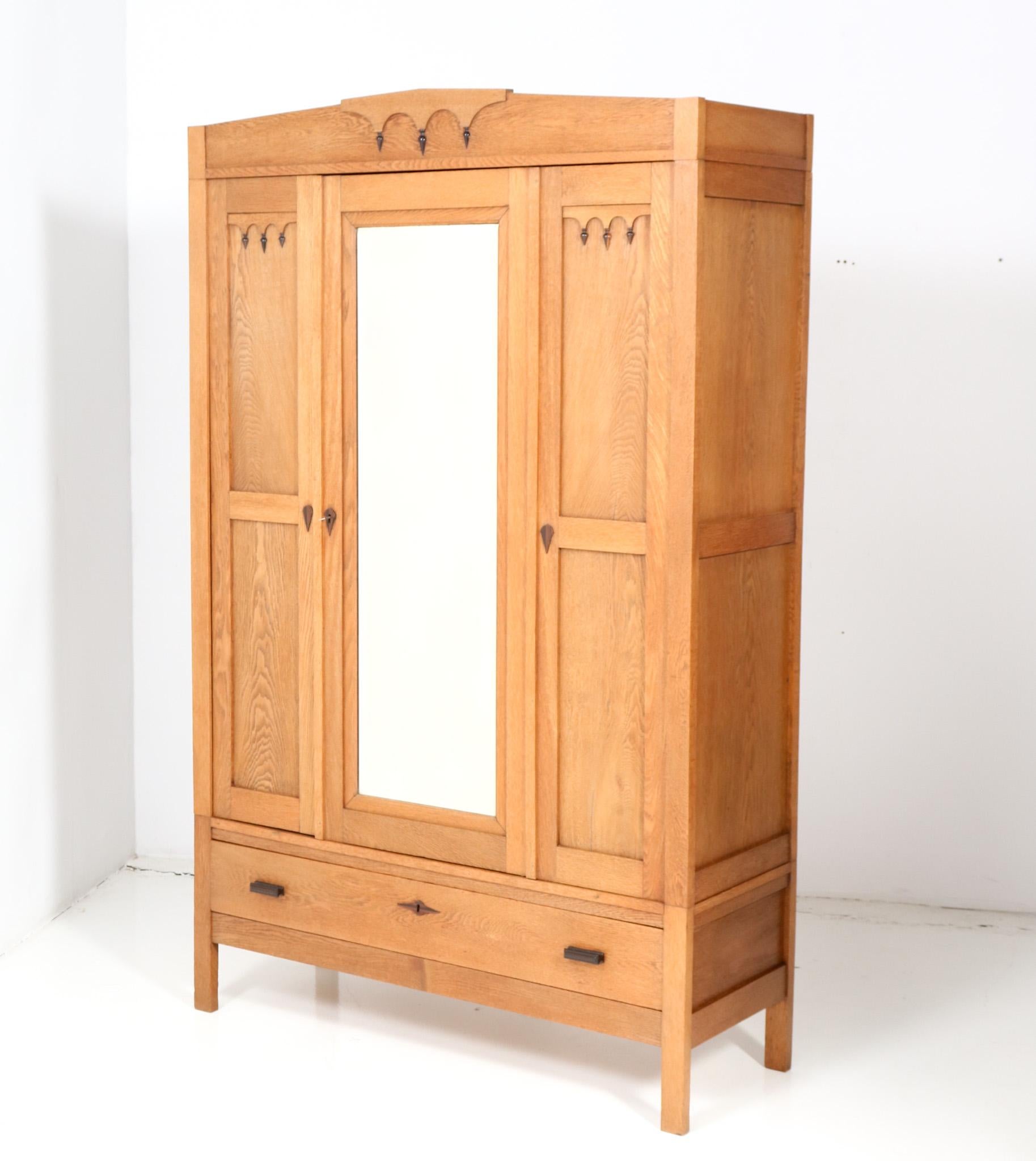 Amazing and rare Art Deco Amsterdam’s School wardrobe or armoire.
Striking Dutch design from the 1920s.
Solid oak and original oak veneered base with solid Macassar ebony handles and elements.
The drawer has also solid Macassar ebony handles.
In