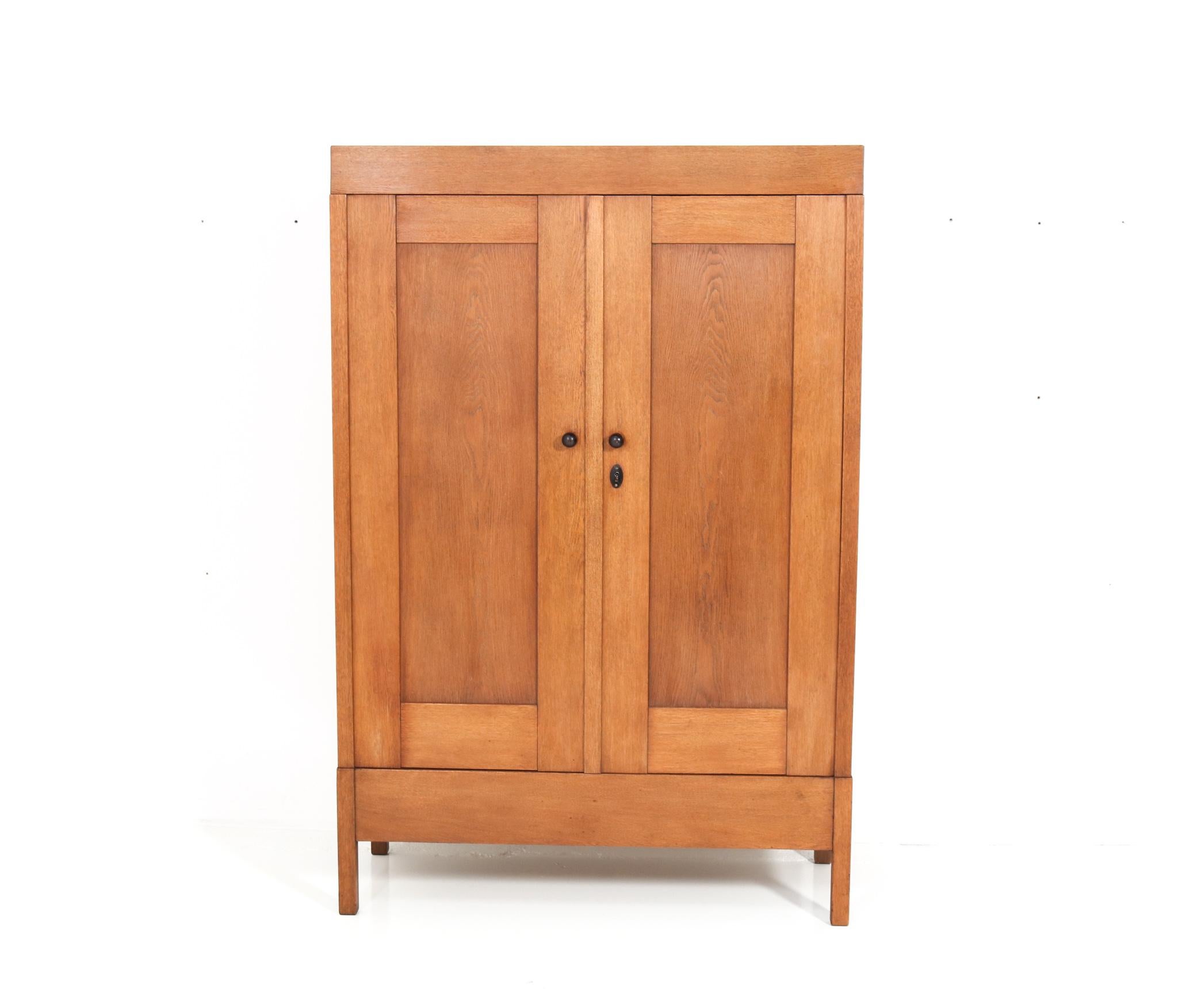 Magnificent and rare Art Deco armoire or wardrobe.
Design by J.A. Muntendam for L.O.V. Oosterbeek.
Striking Dutch Haagse School design from the 1920s.
Solid oak with original solid macassar ebony knobs.
Four original wooden shelves adjustable in