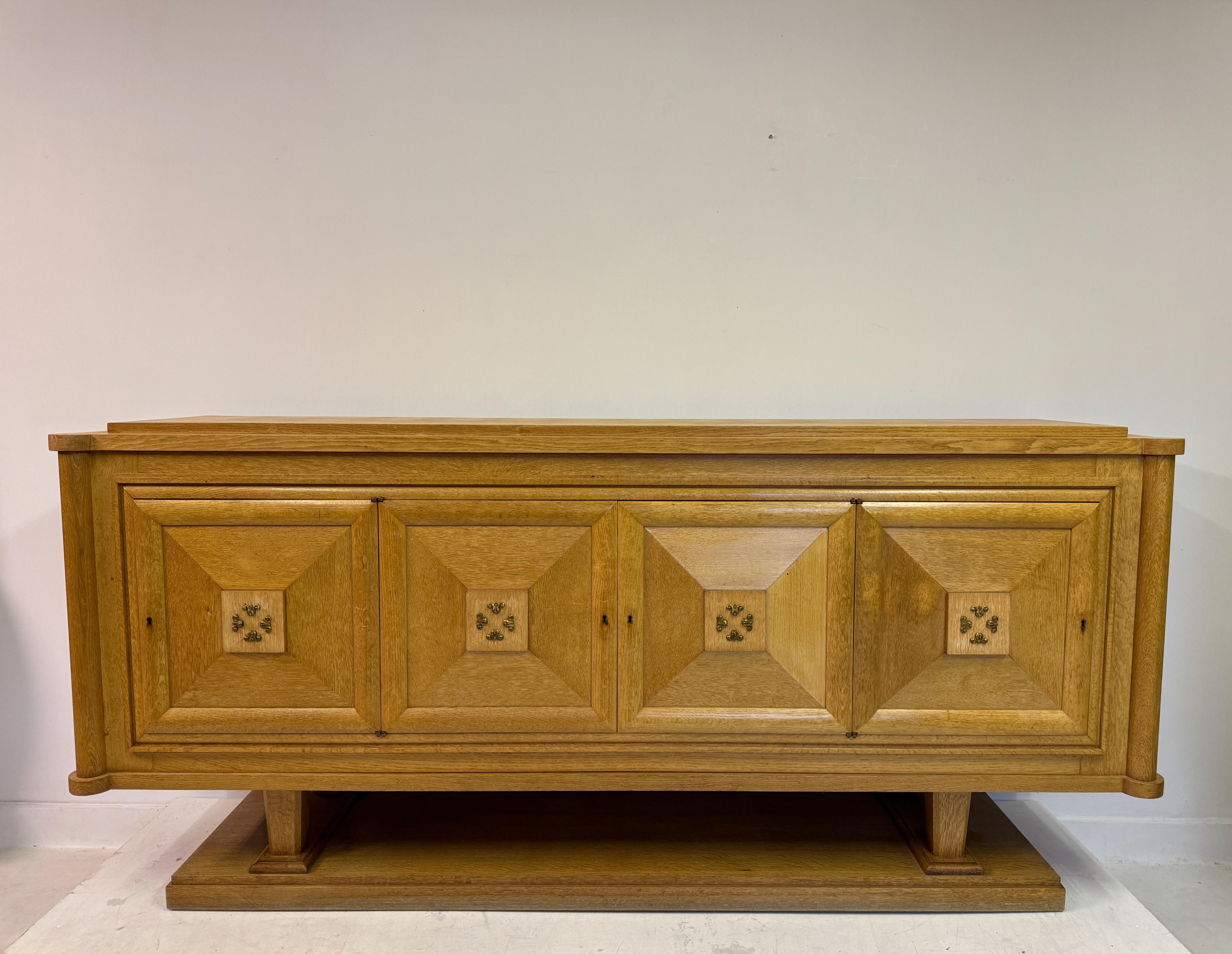 Questa credenza è uno straordinario mix di elementi di design Art Deco e Brutalista degli anni '30 e '40. È realizzato in quercia e mette in mostra la naturale bellezza e resistenza del legno con una finitura calda e color miele che ne mette in