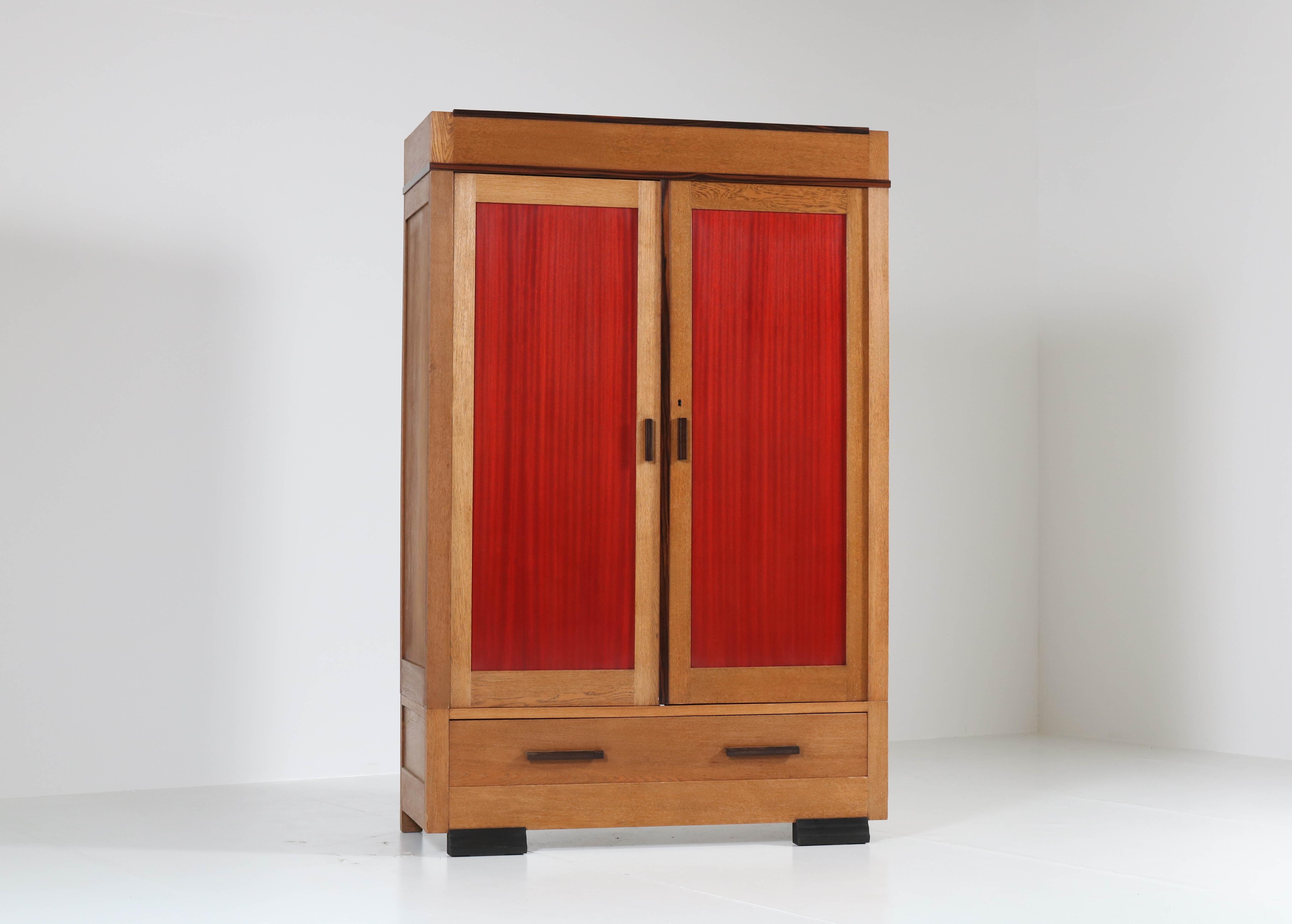 Stunning and rare Art Deco Haagse School armoir or wardrobe.
Design by Fa. Drilling Amsterdam.
Striking Dutch design from the 1920s.
Solid oak and solid ebony Macassar with mahogany panels in the doors.
This wardrobe can be dismantled for easy