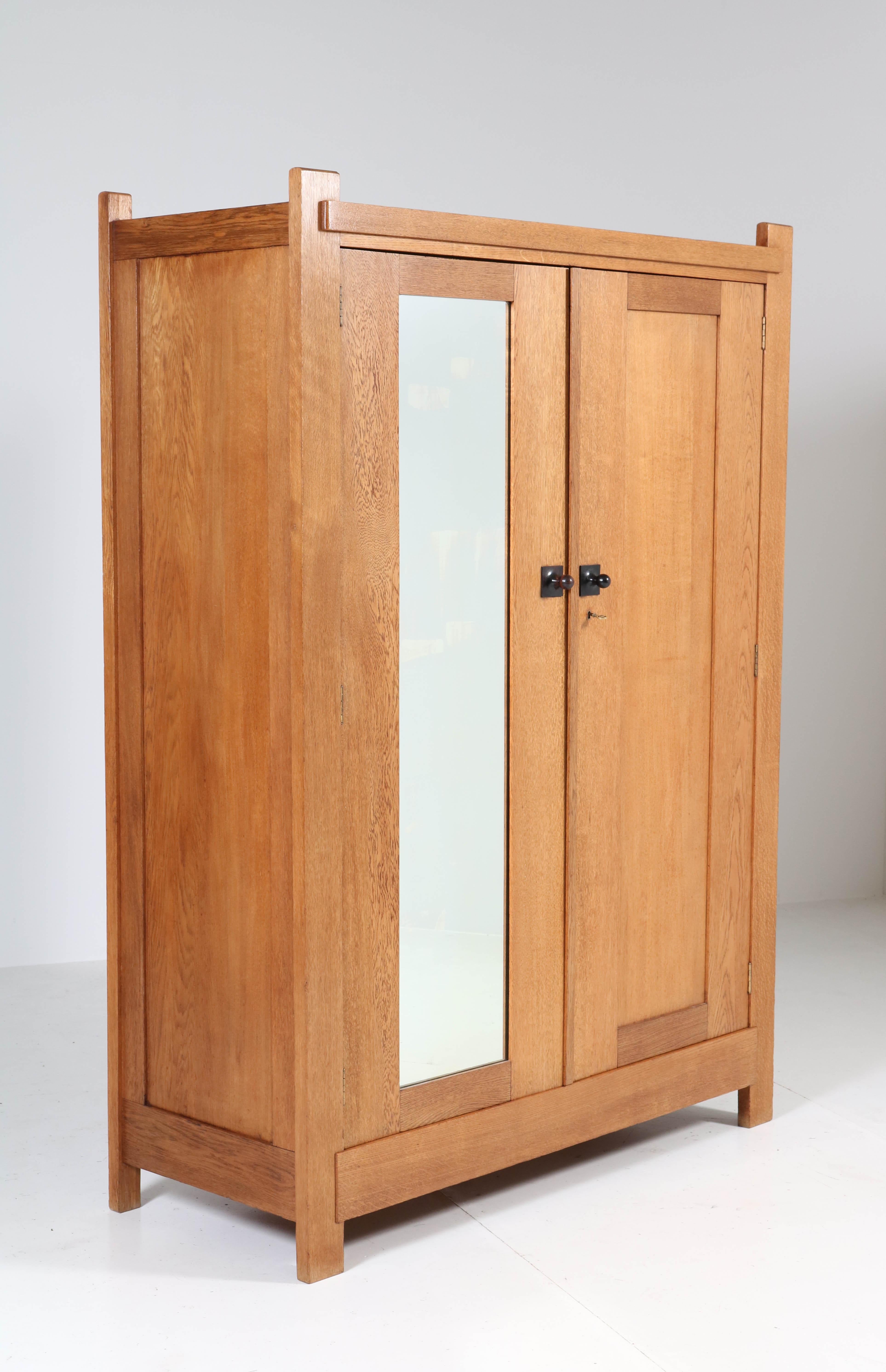 Stunning Art Deco Haagse School armoir or wardrobe.
Design by Henk Wouda for H. Pander & Zonen.
Striking Dutch design from the 1920s.
Solid oak with original black lacquered wooden knobs.
Marked with metal tag and brand mark and original Pander