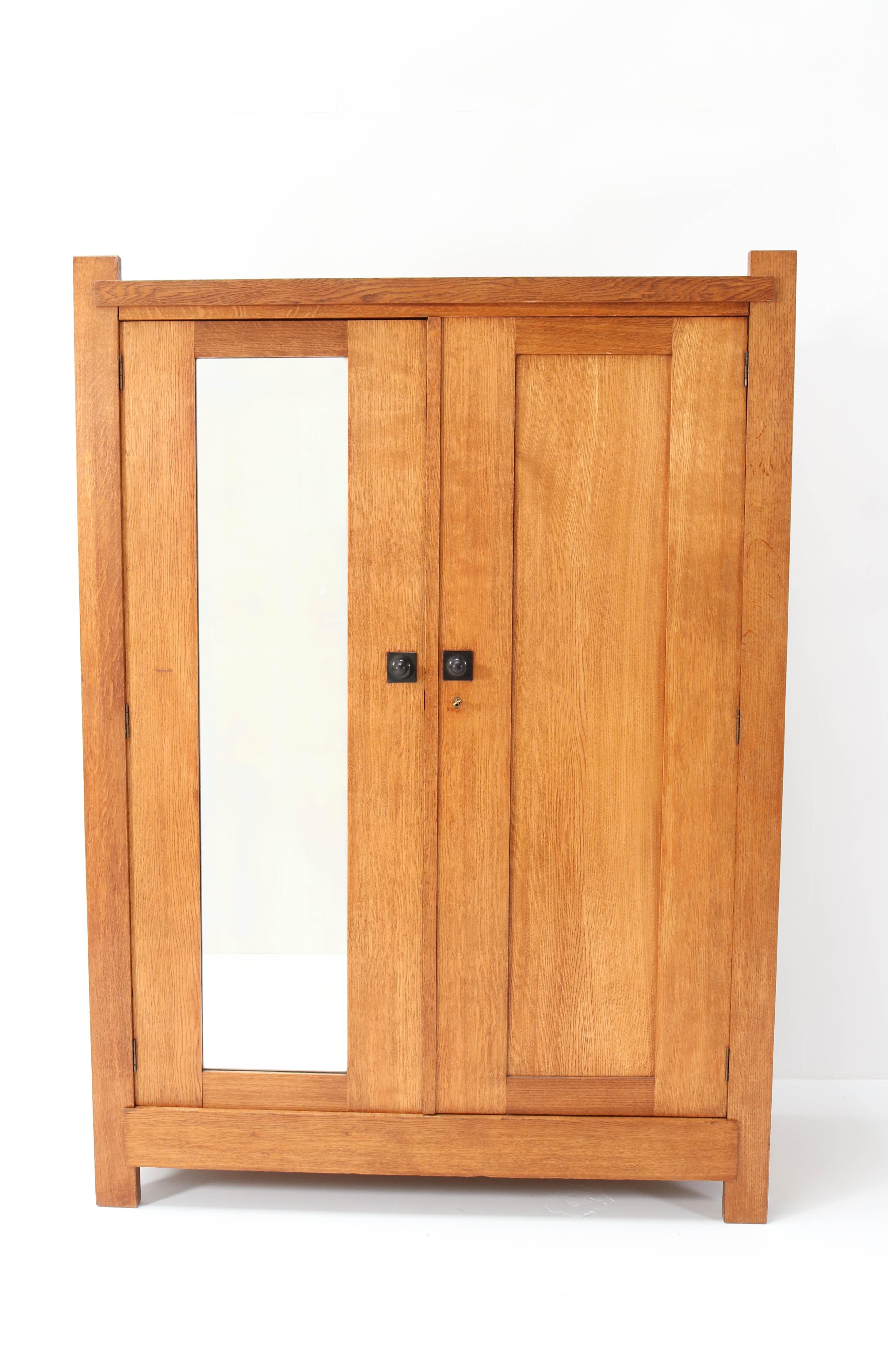 Stunning Art Deco Haagse School armoir or wardrobe.
Design by Hendrik Wouda for H. Pander & Zonen.
Striking Dutch design from the 1920s.
Solid oak with original black lacquered wooden knobs.
Marked with metal tag and brand mark and original Pander
