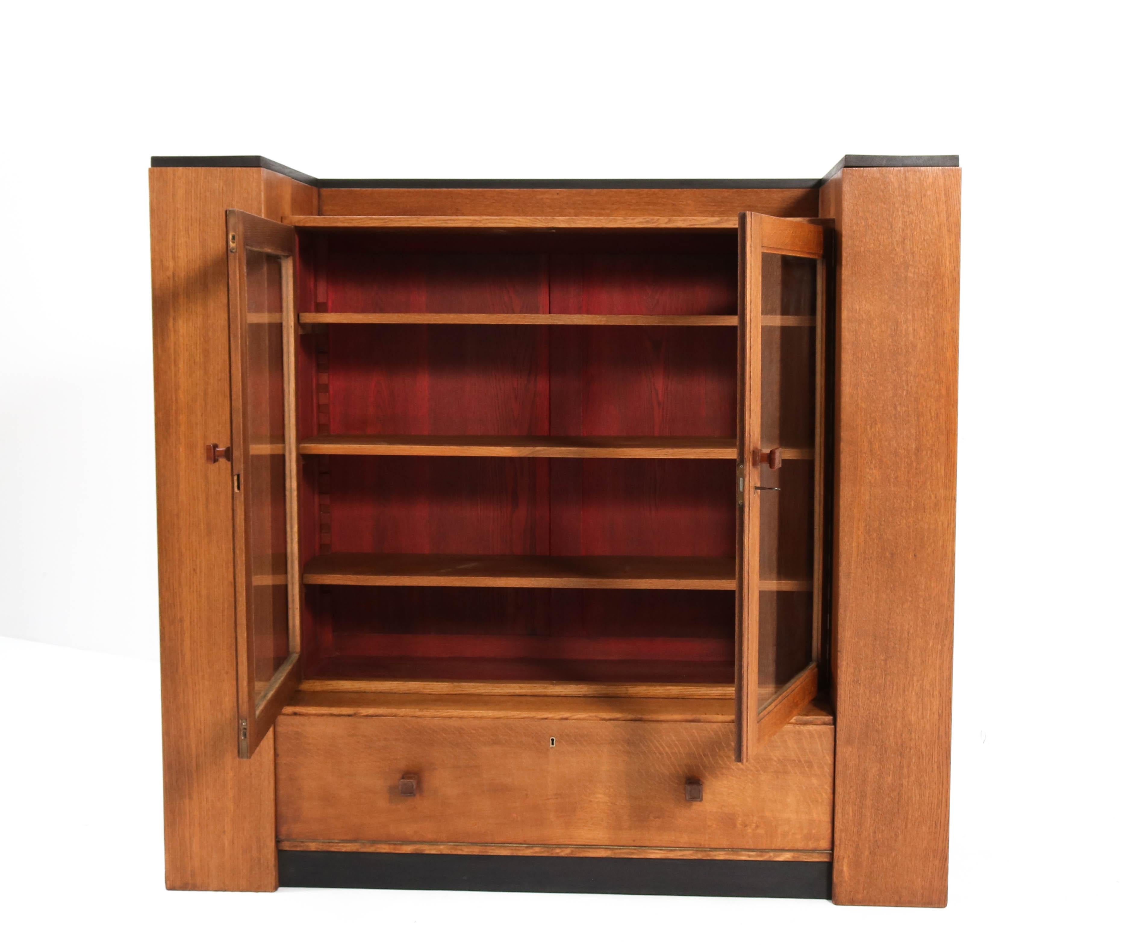 Magnificent and rare Art Deco Haagse School bookcase.
Design by Hendrik Wouda for Metz & Co. Amsterdam.
Striking Dutch design from the 1930s.
Solid oak with original padouk knobs.
Eleven original solid oak shelves adjustable in height.
In very