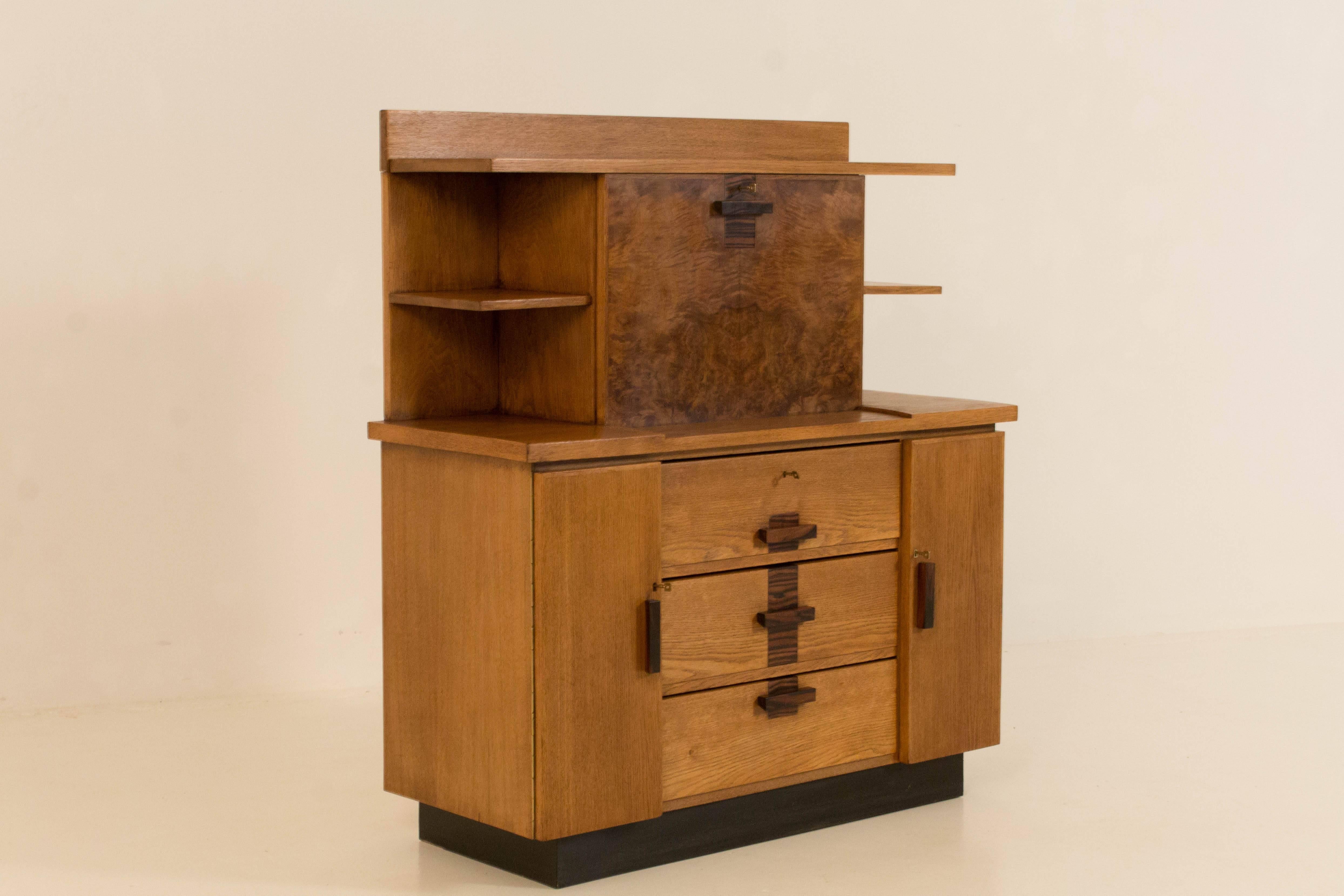 Oak Art Deco Haagse school bookcase with drop-front desk.
Design by P.E.L.Izeren for Genneper Molen.
Striking Dutch design from the twenties.
Solid ebony Macassar handles on doors and drawers.
The veneer on the drop-front is made from walnut and