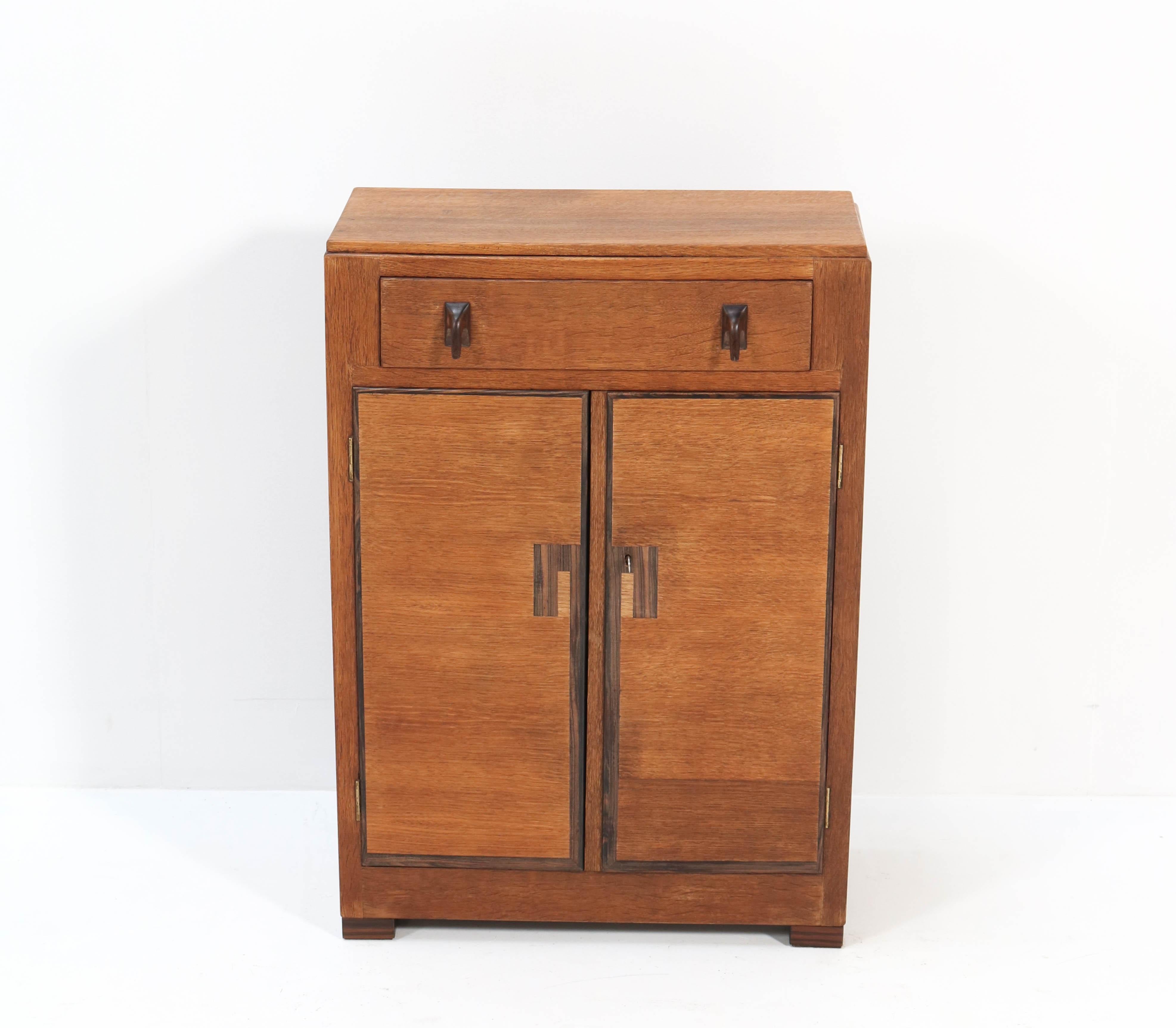 Stunning and rare Art Deco Haagse School cabinet.
Design by Anton Lucas for NV. Meubelkunst Leiden.
Striking Dutch design from the 1920s.
Solid oak with solid Macassar ebony knobs and lining.
In good original condition with minor wear consistent