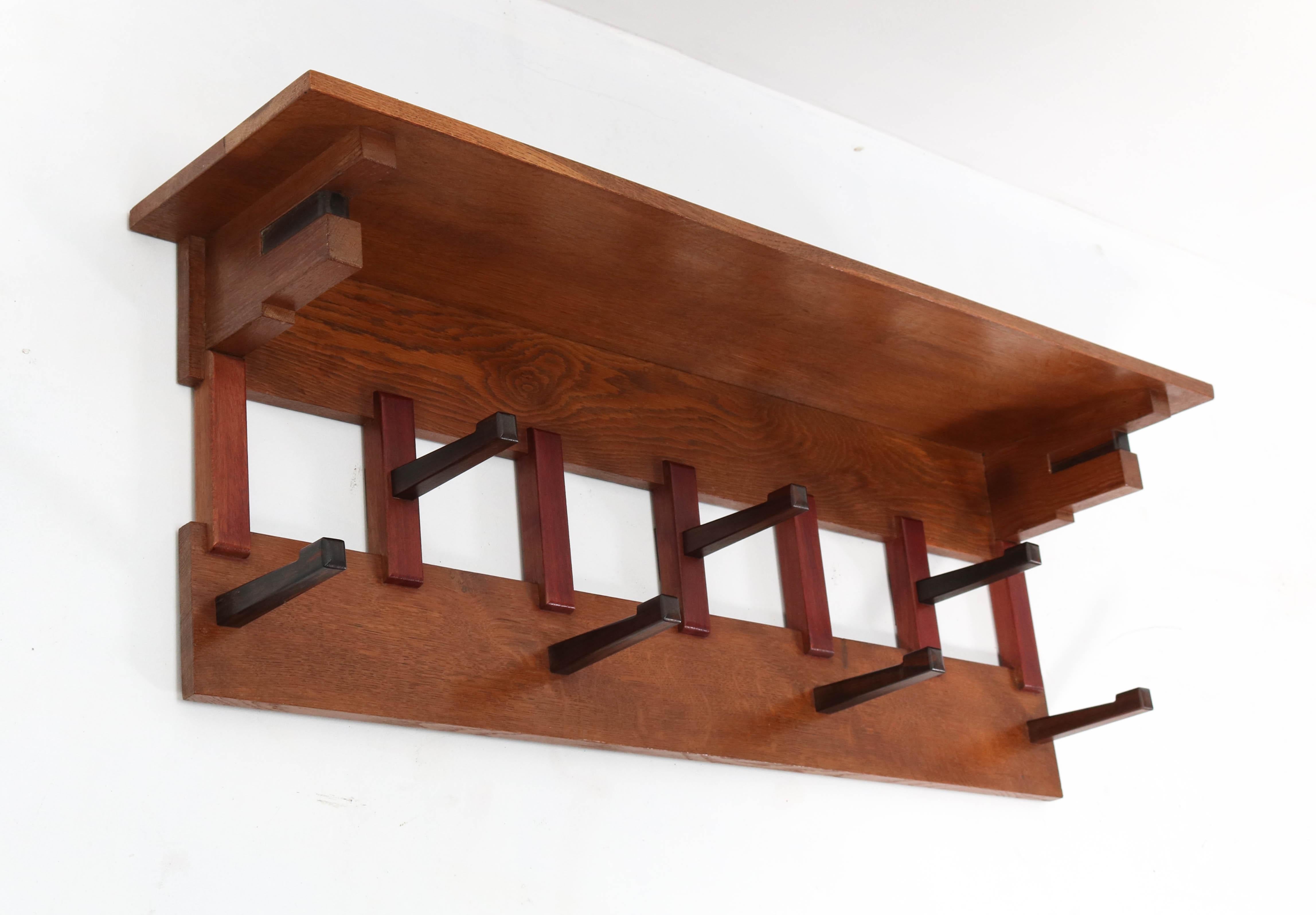 Stunning and elegant Art Deco Haagse School coat rack.
Design by P.E.L. Izeren for Genneper Molen.
Striking Dutch design from the twenties.
Solid oak and mahogany with 7 original solid Macassar ebony hooks.
Marked with original manufacturers