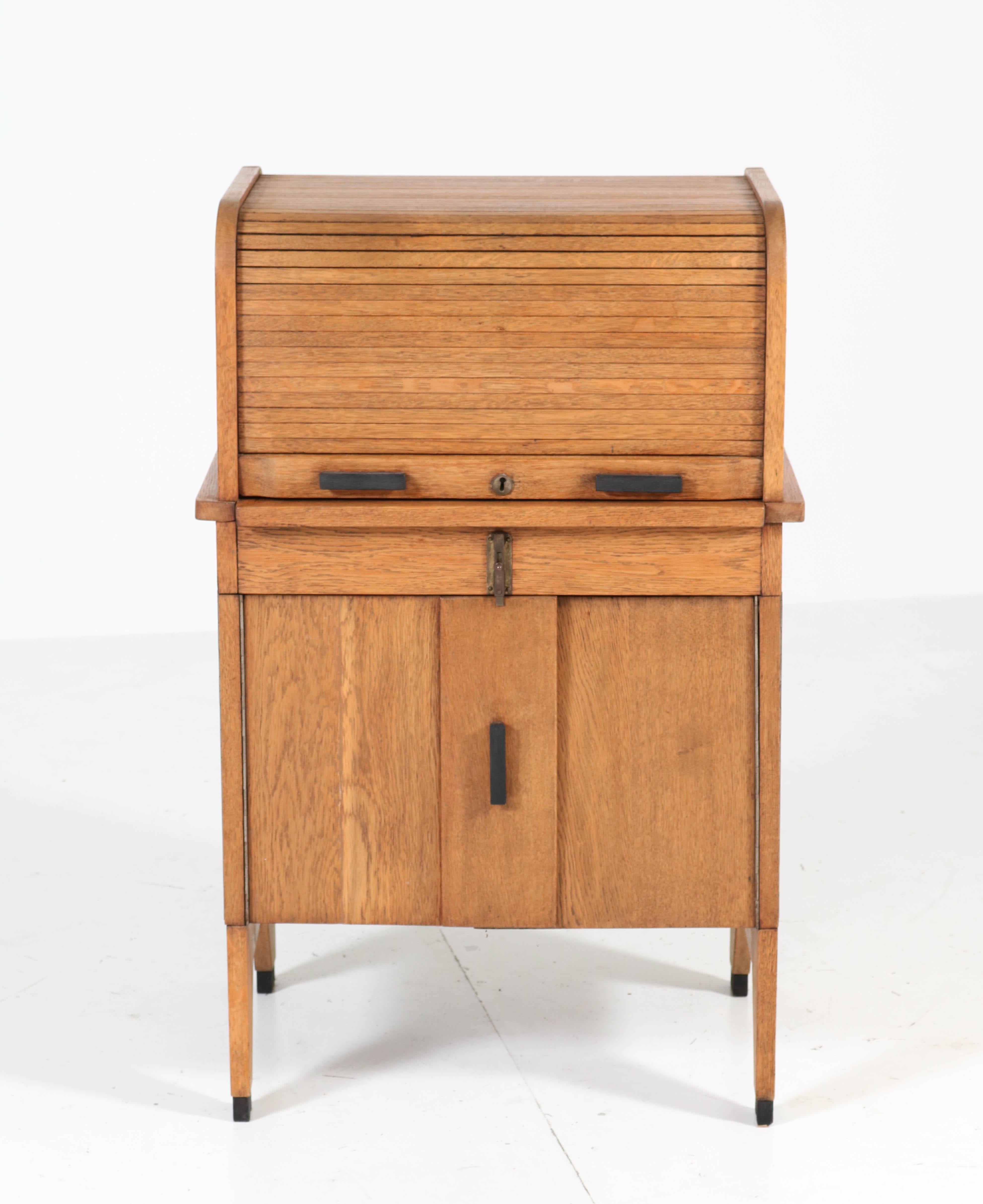 Rare and hard to find Art Deco Haagse School roll top desk.
Solid oak with ebonized handles.
Striking Dutch design from the 1920s.
By pulling down the roll top at the back, this stunning piece of furniture transforms in a pedestal desk!
Width of