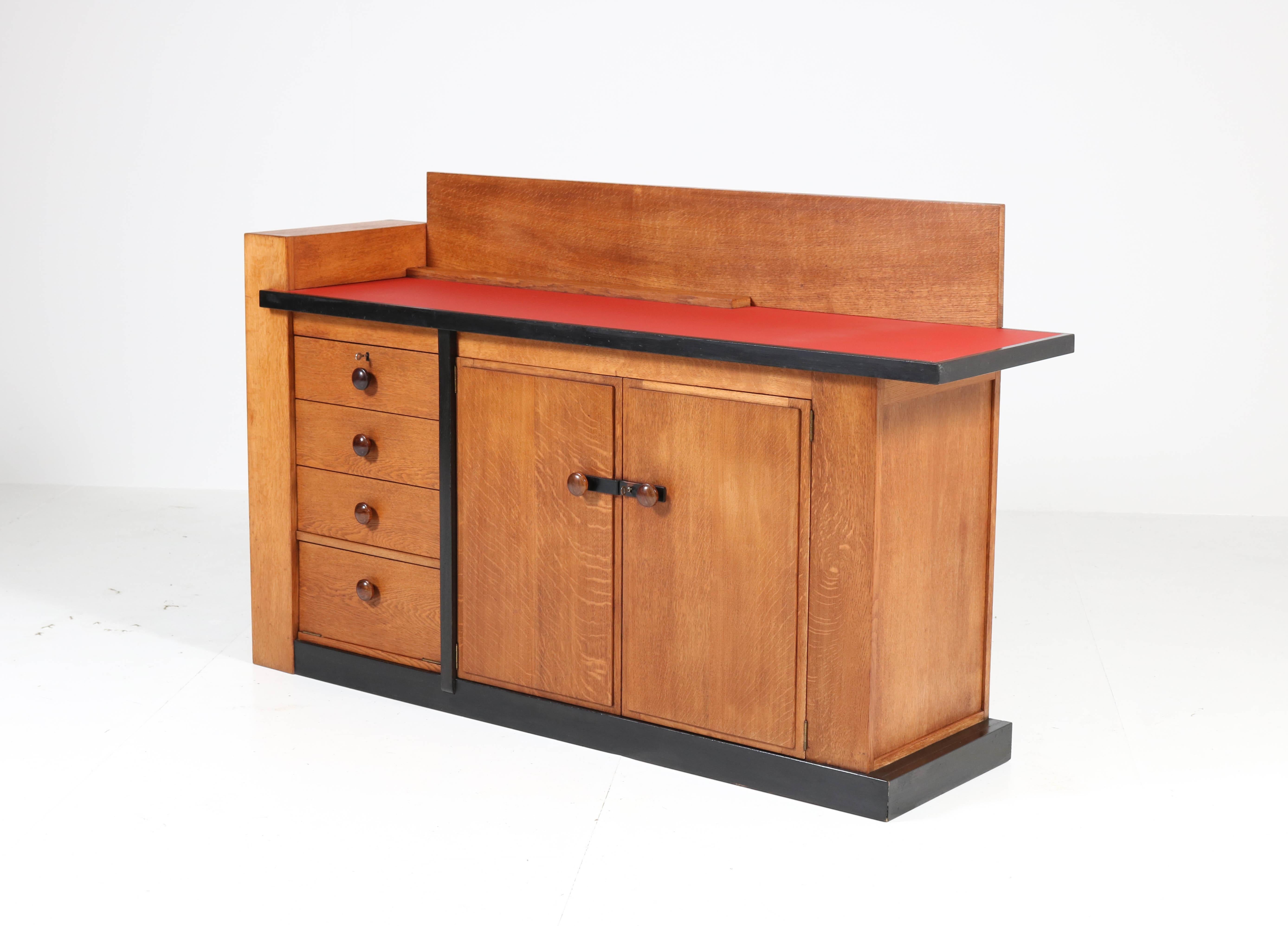 Magnificent and very rare Art Deco Haagse School sideboard.
Design by Jan Brunott.
Striking Dutch design from the twenties.
Solid oak with original solid ebony Macassar knobs and original black lacquered lining.
The top is renewed with red