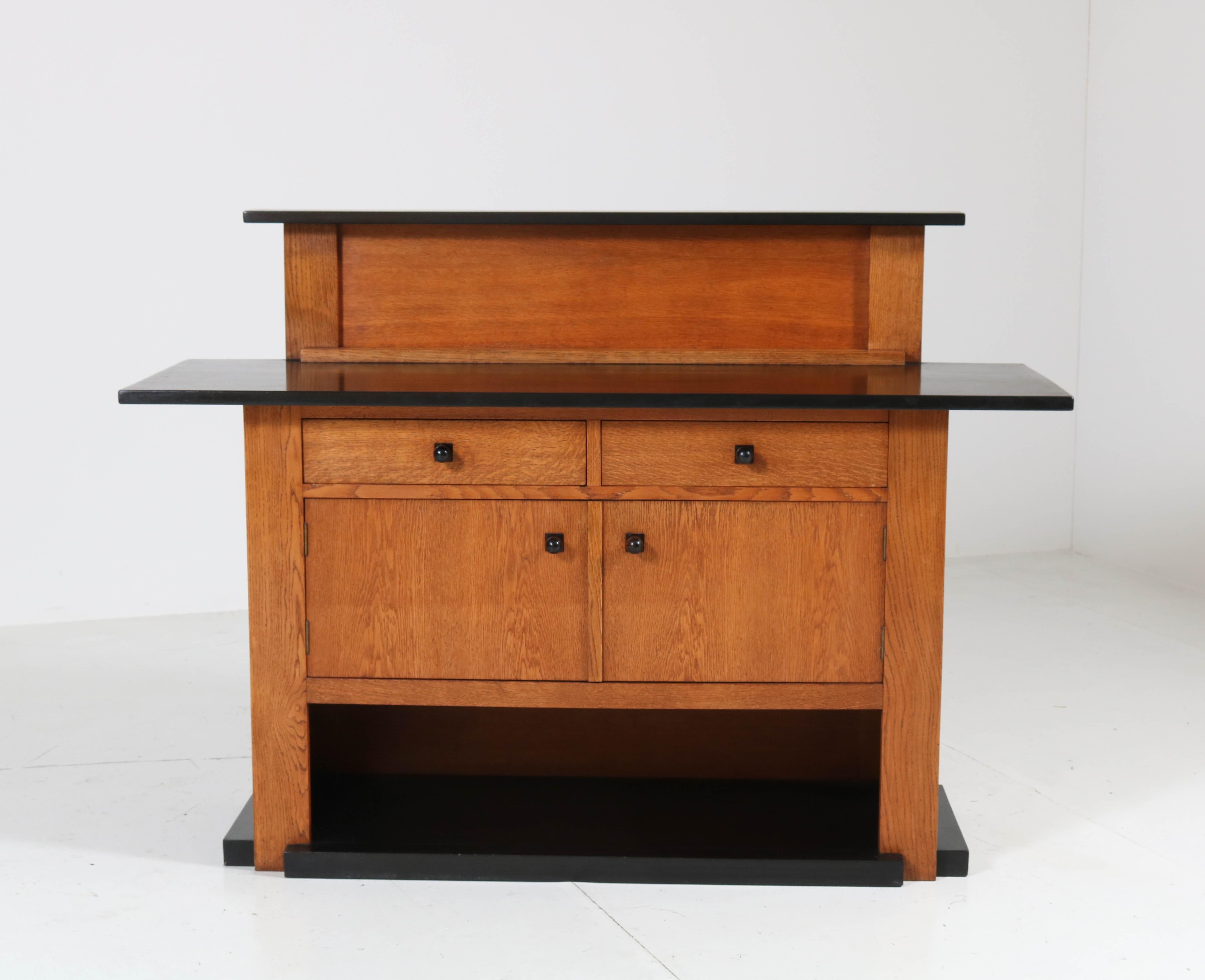 Magnificent and very rare Art Deco Haagse School sideboard or credenza.
Design by J.C. Jansen for L.O.V. Oosterbeek.
Striking Dutch design from the 1920s!
Solid oak with original black lacquered top and knobs.
Marked with original manufacturers