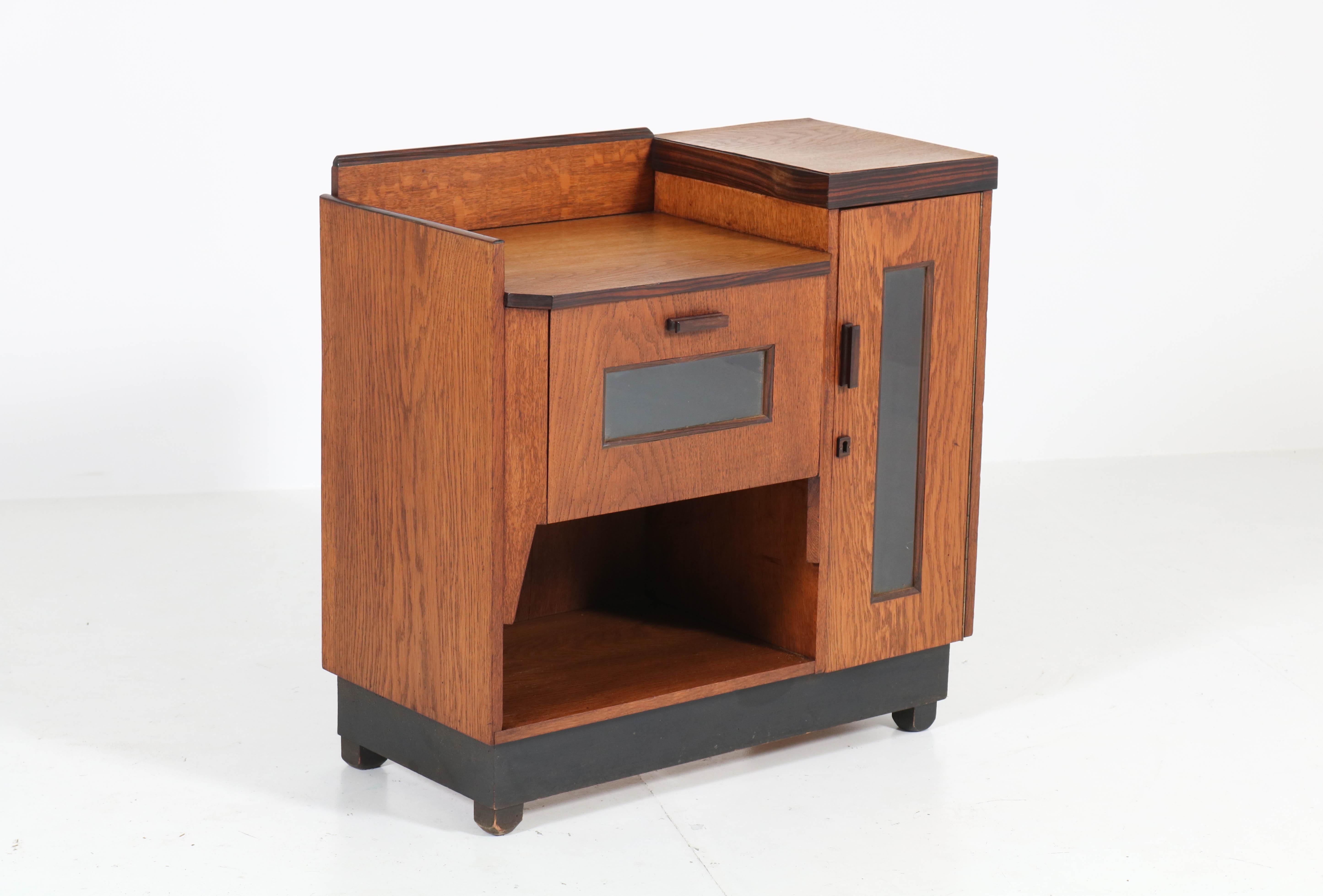 Wonderful and rare Art Deco Haagse School tea cabinet.
Design by P.E.L. Izeren for Genneper Molen.
Striking Dutch design from the 1920s.
Solid oak with oak veneer and solid ebony Macassar handles and lining.
In very good original condition with