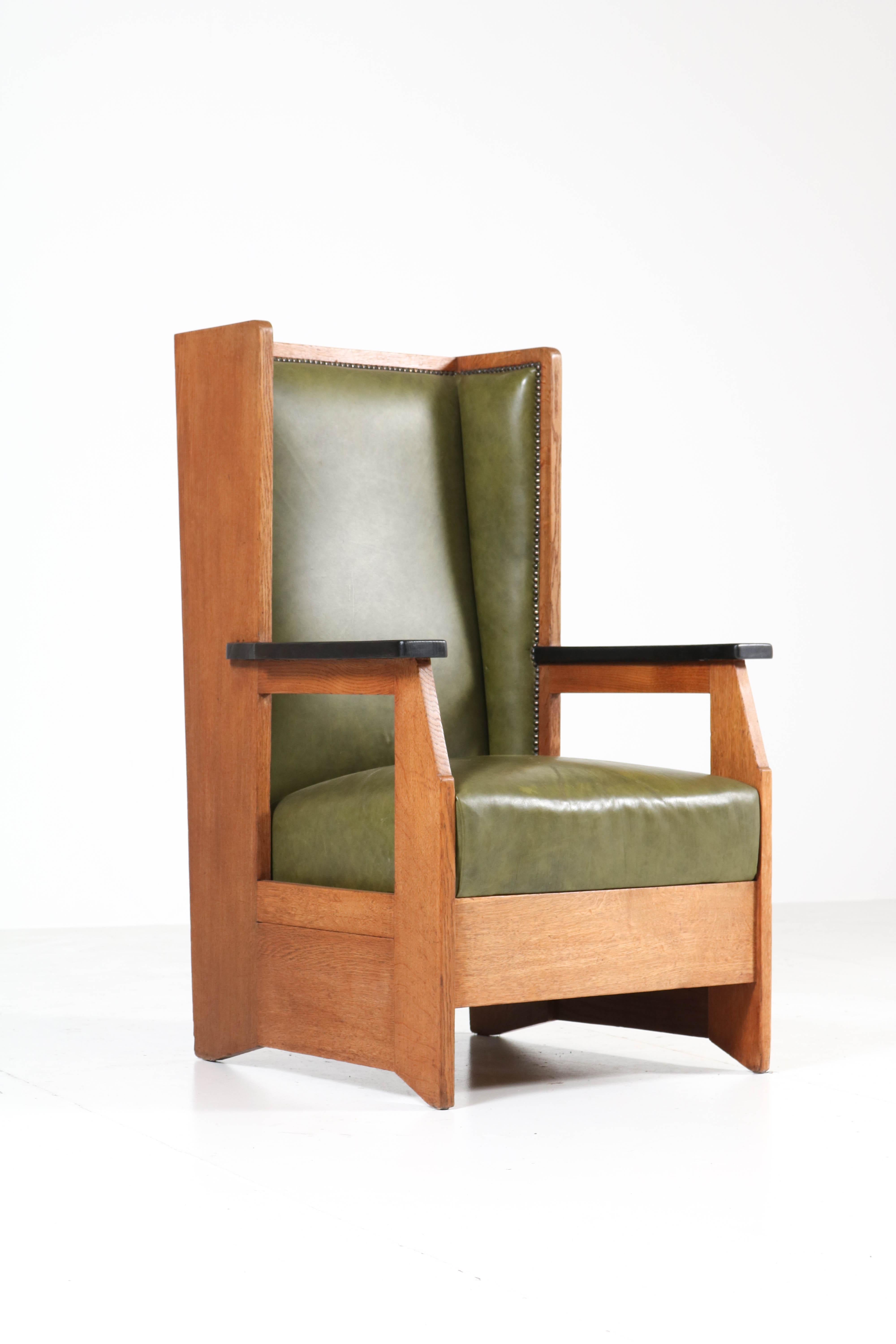 Stunning and rare Art Deco Haagse School wingback chair.
Design by Henk Wouda for Pander.
Striking Dutch design from the 1920s.
Marked with original metal tag.
Solid oak with later green leather upholstery.
In good original condition with minor