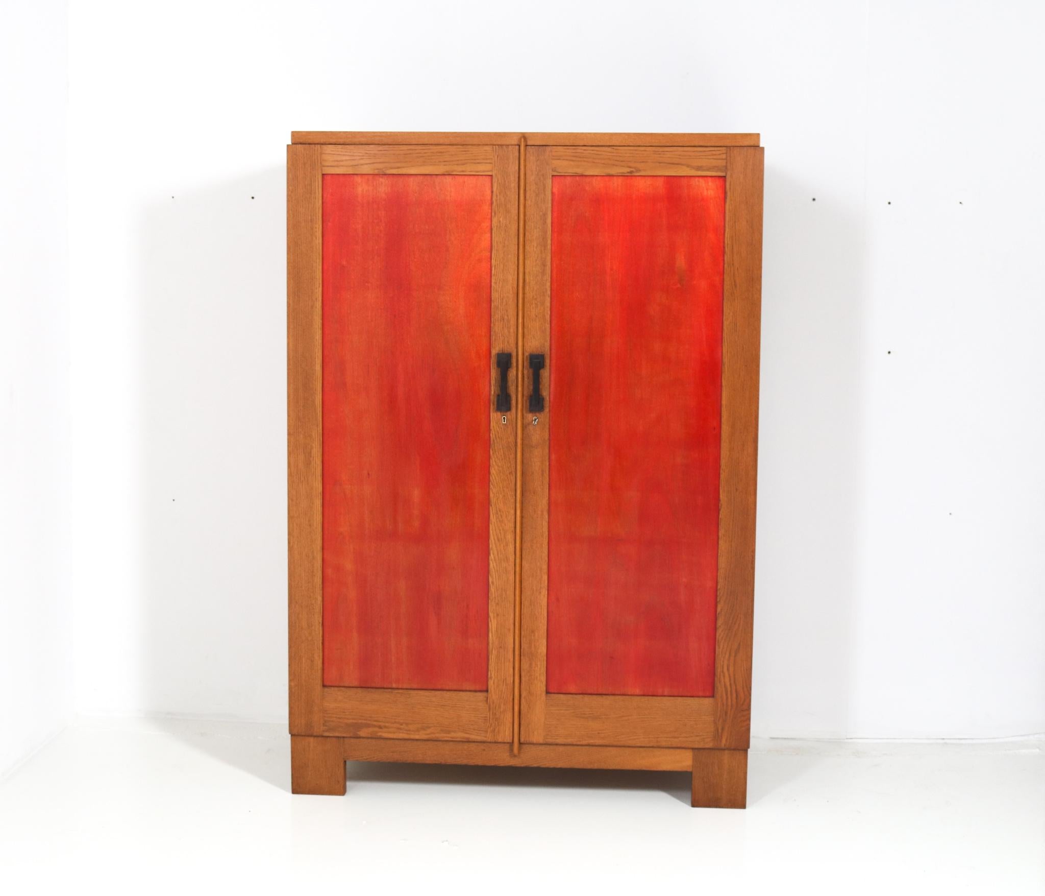 Magnificent and rare Art Deco Haagse School armoire or wardrobe.
Design by Cor Alons.
Striking Dutch design from the 1920s.
Solid oak frame with original red lacquered panels in doors and sides.
Six original oak shelves adjustable in