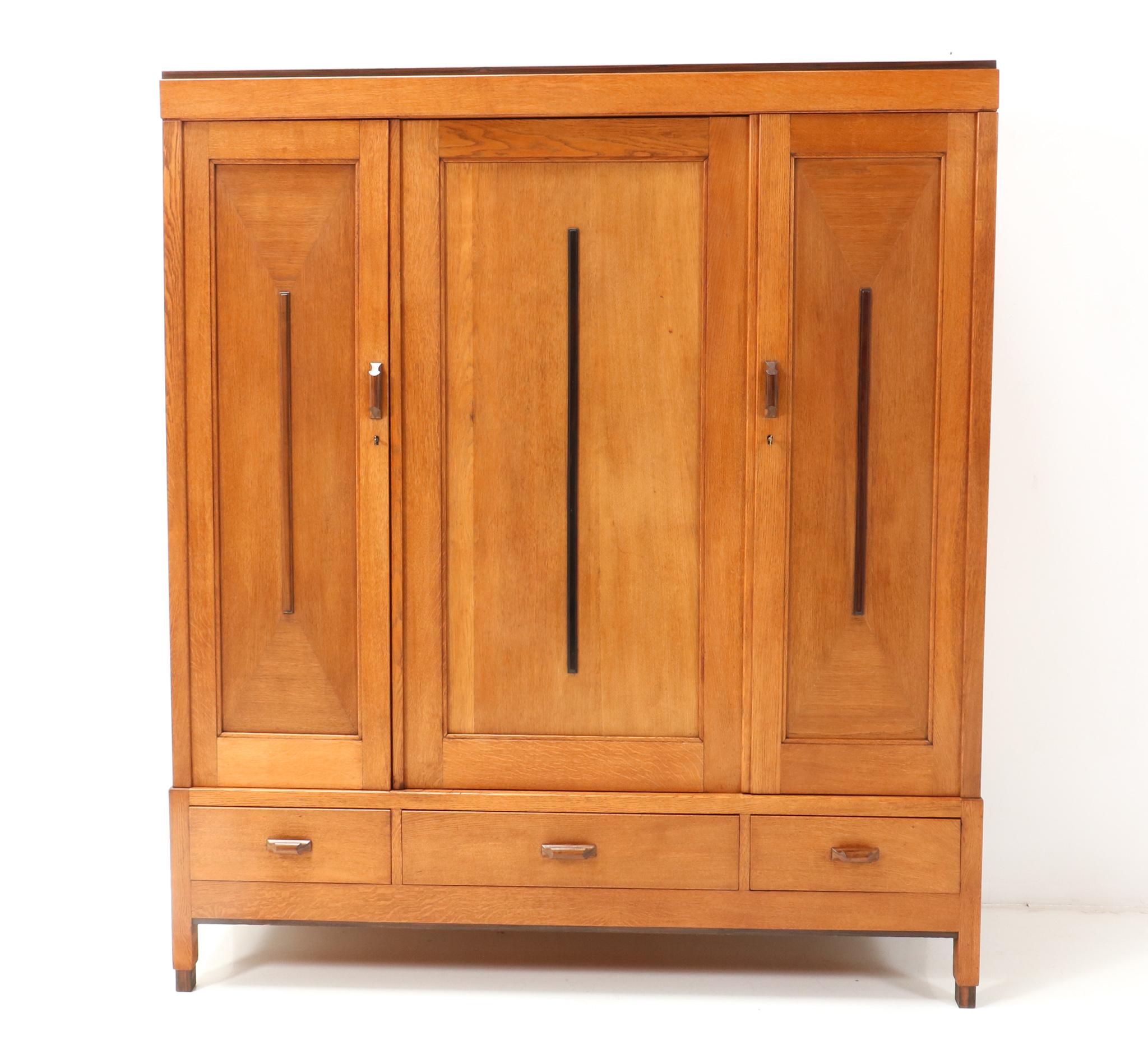 Magnificent and rare Art Deco Modernist armoire or wardrobe.
Design attributed to Fa Drilling Amsterdam.
Striking Dutch design from the 1920s.
Solid oak with solid macassar ebony lining in the three doors.
This elegant piece of furniture will be
