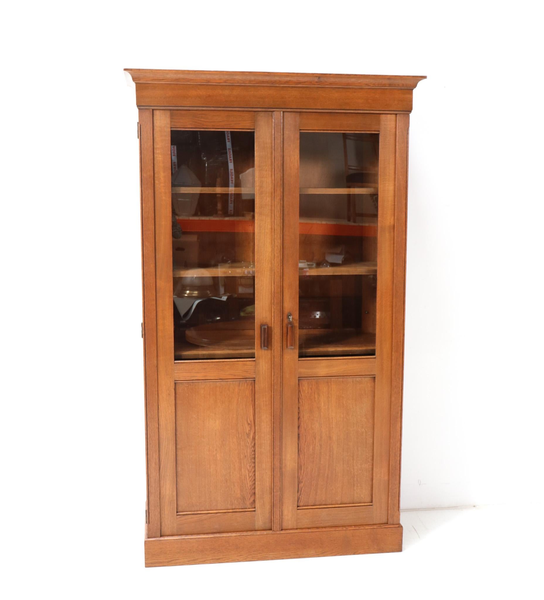 Stunning and rare Art Deco Modernist bookcase.
Striking Dutch design from the 1920s.
Solid oak with original macassar ebony handles on both doors.
The backside panels are also made out of solid oak.
Four original solid oak shelves, adjustable in