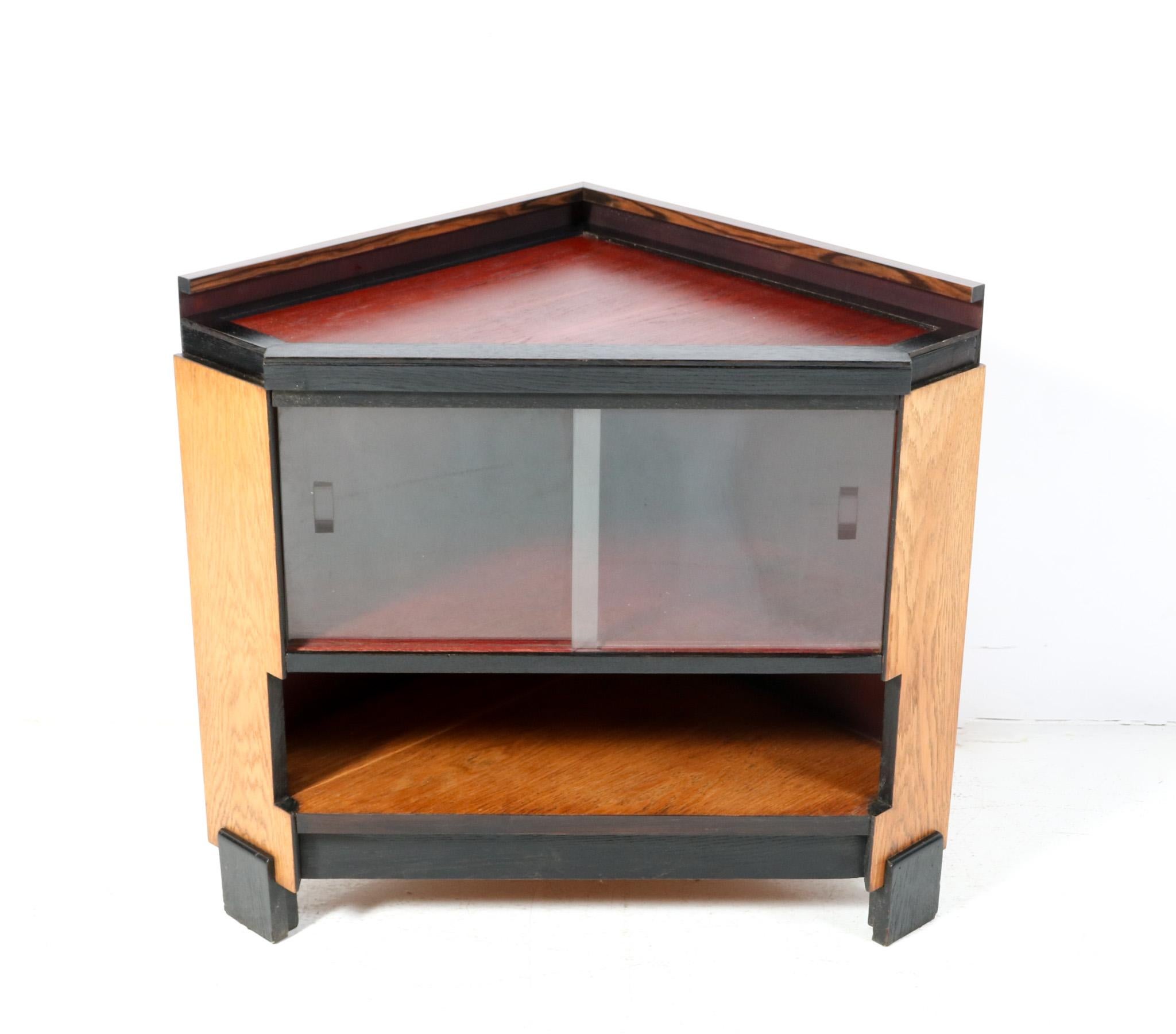 Magnificent and ultra rare Art Deco Modernist corner cabinet.
Design in the style of Jan Brunott.
Striking Dutch design from the 1920s.
Solid oak base with original black lacquered lining.
Original red lacquered top with solid macassar ebony