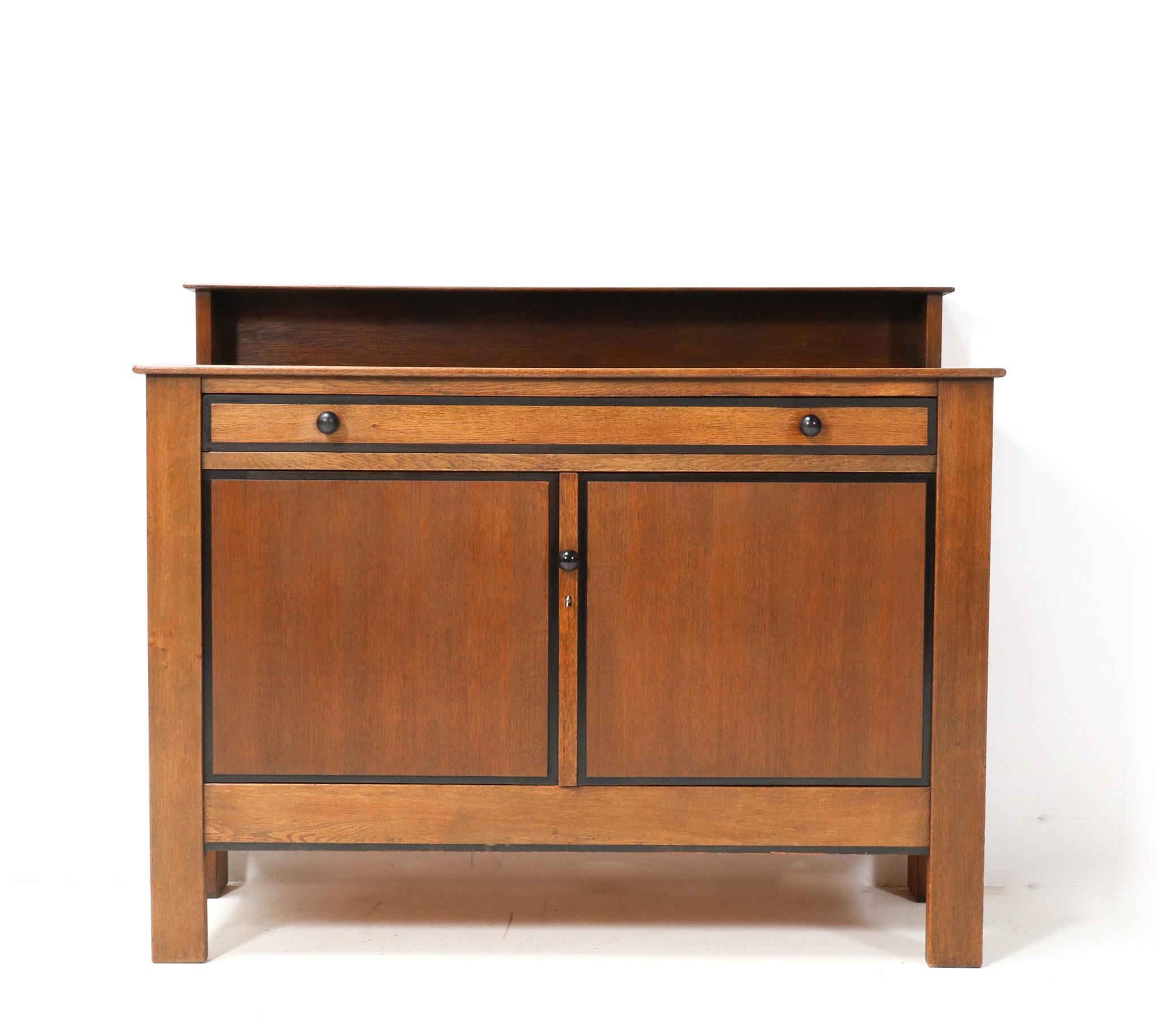 Stunning and decorative Art Deco Modernist credenza or sideboard.
Design by J.A. Muntendam for L.O.V. Oosterbeek.
Striking Dutch design from the 1920s.
Solid oak with original solid macassar ebony knobs on drawer and door.
In very good original