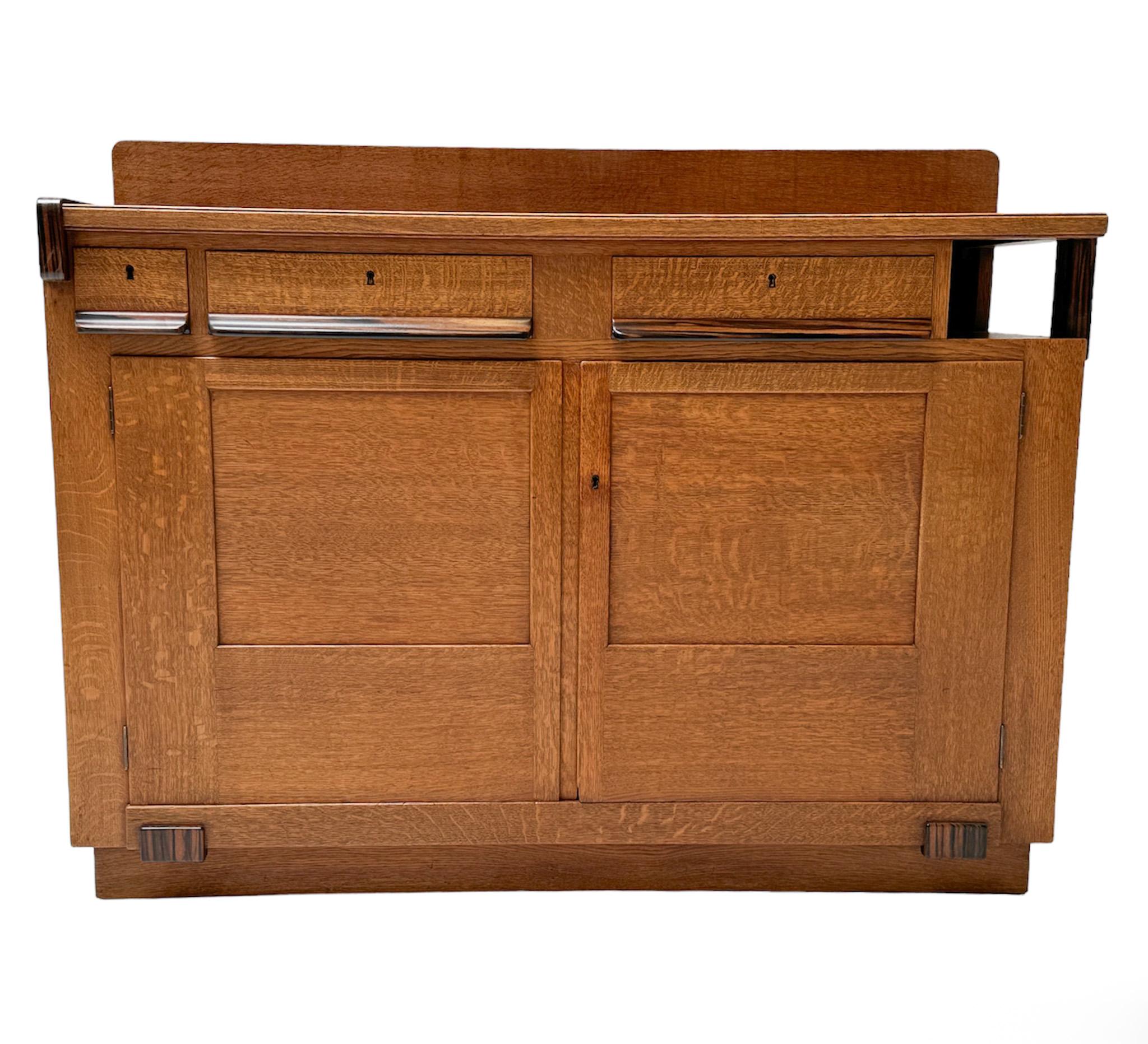Magnificent and rare Art Deco Modernist credenza or sideboard.
Design by Anton Lucas for N.V. Meubelkunst Leiden.
Striking Dutch design from the 1920s.
Solid oak base with original solid macassar ebony handles on doors and drawers.
In very good