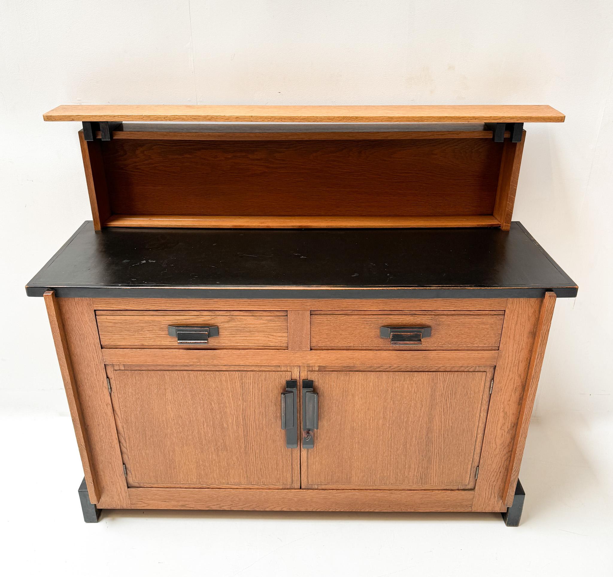 Magnificent and ultra rare Art Deco Modernist credenza or sideboard.
Design by Jan Brunott.
Striking Dutch design from the 1920s.
Solid oak base with original black lacquered handles on both doors and drawers.
Original black lacquered linoleum