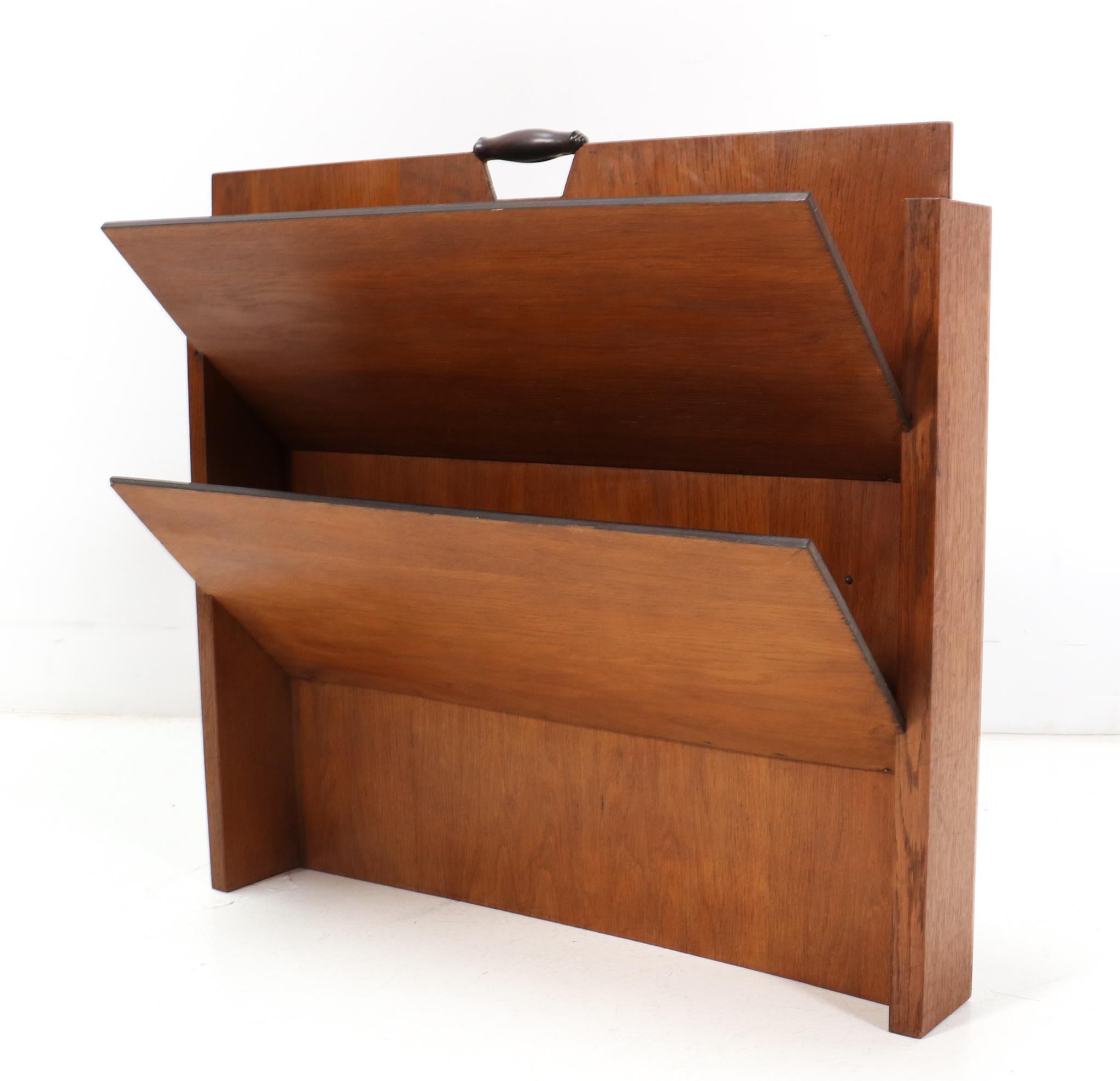 Amazing and rare Art Deco Modernist magazine rack.
Design by Frits Spanjaard for L.O.V. Oosterbeek.
Striking Dutch design from the 1920s.
Solid oak and original oak veneered frame with two original macassar ebony veneered shelves.
Elegant and