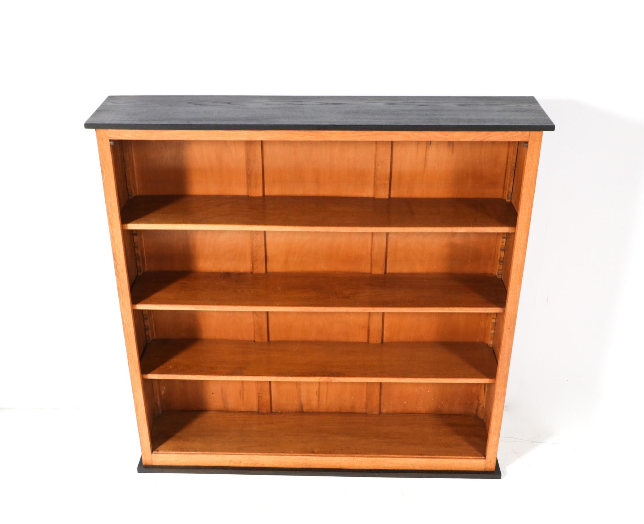 Stunning and rare Art Deco Modernist open bookcase.
Design by Jan Brunott.
Striking Dutch design from the 1920s.
Solid oak base with original black lacquered top and lining.
Three original solid oak shelves, adjustable in height.
In very good