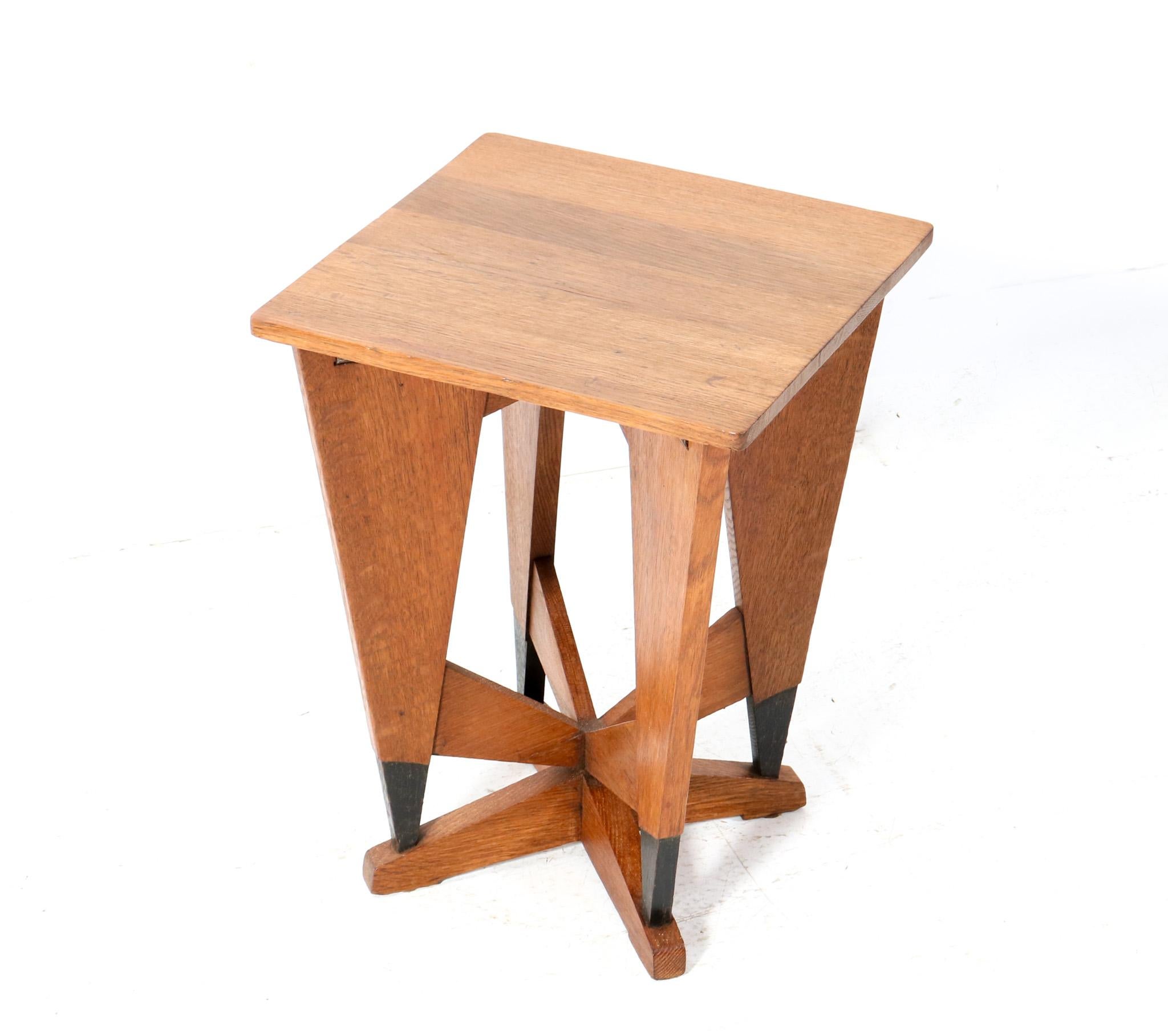 Stunning and rare Art Deco Modernist side table.
Design by P.E.L. Izeren for De Genneper Molen.
Striking Dutch design from the 1920s.
Solid oak base and top with original black lacquered elements.
In very good original condition with minor wear