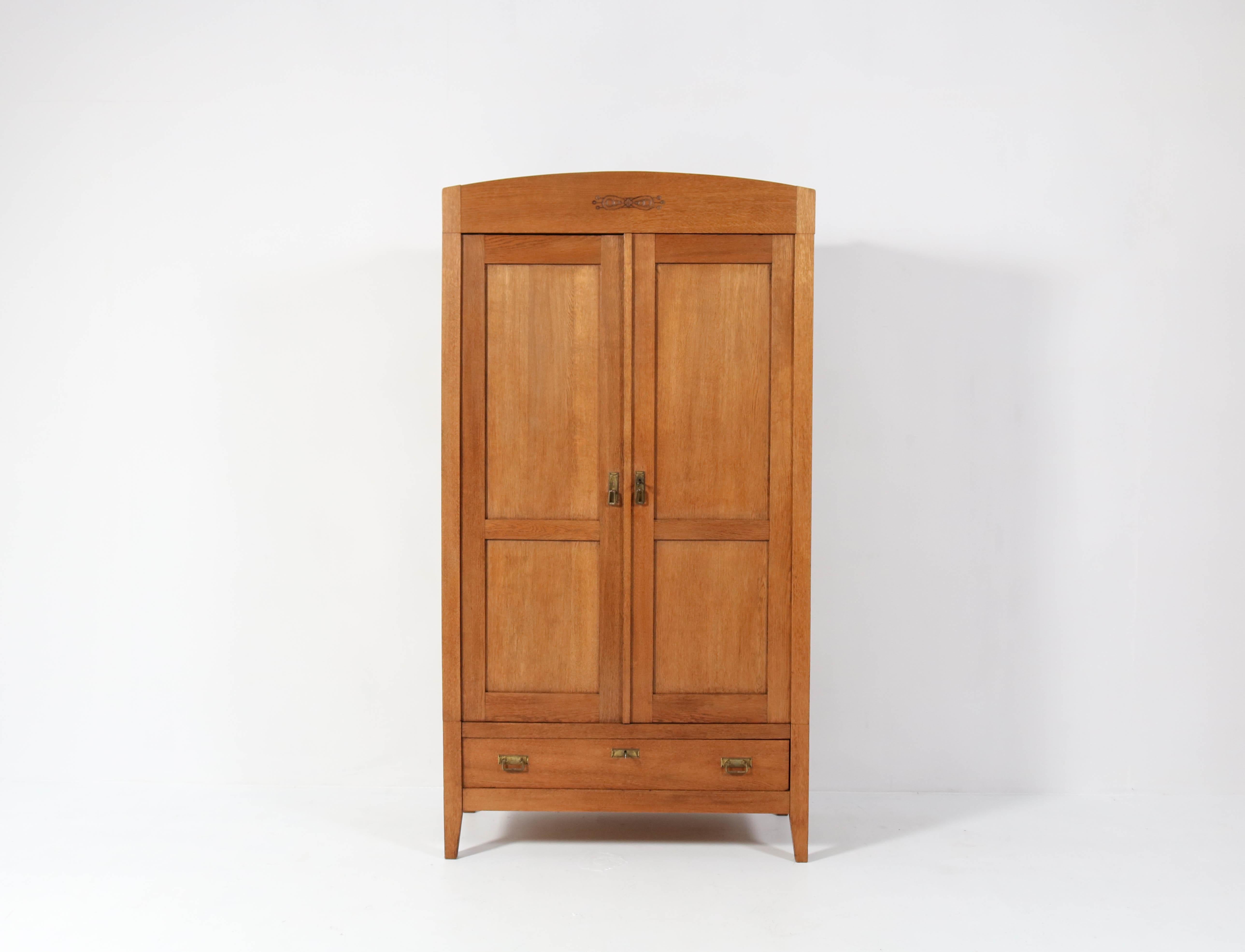Stunning Art Nouveau Arts & Crafts armoire or wardrobe.
Striking Dutch design from the 1900s.
Solid oak with original brass handles on doors and drawer.
Three original solid oak shelves, one with two drawers adjustable in height.
This wonderful