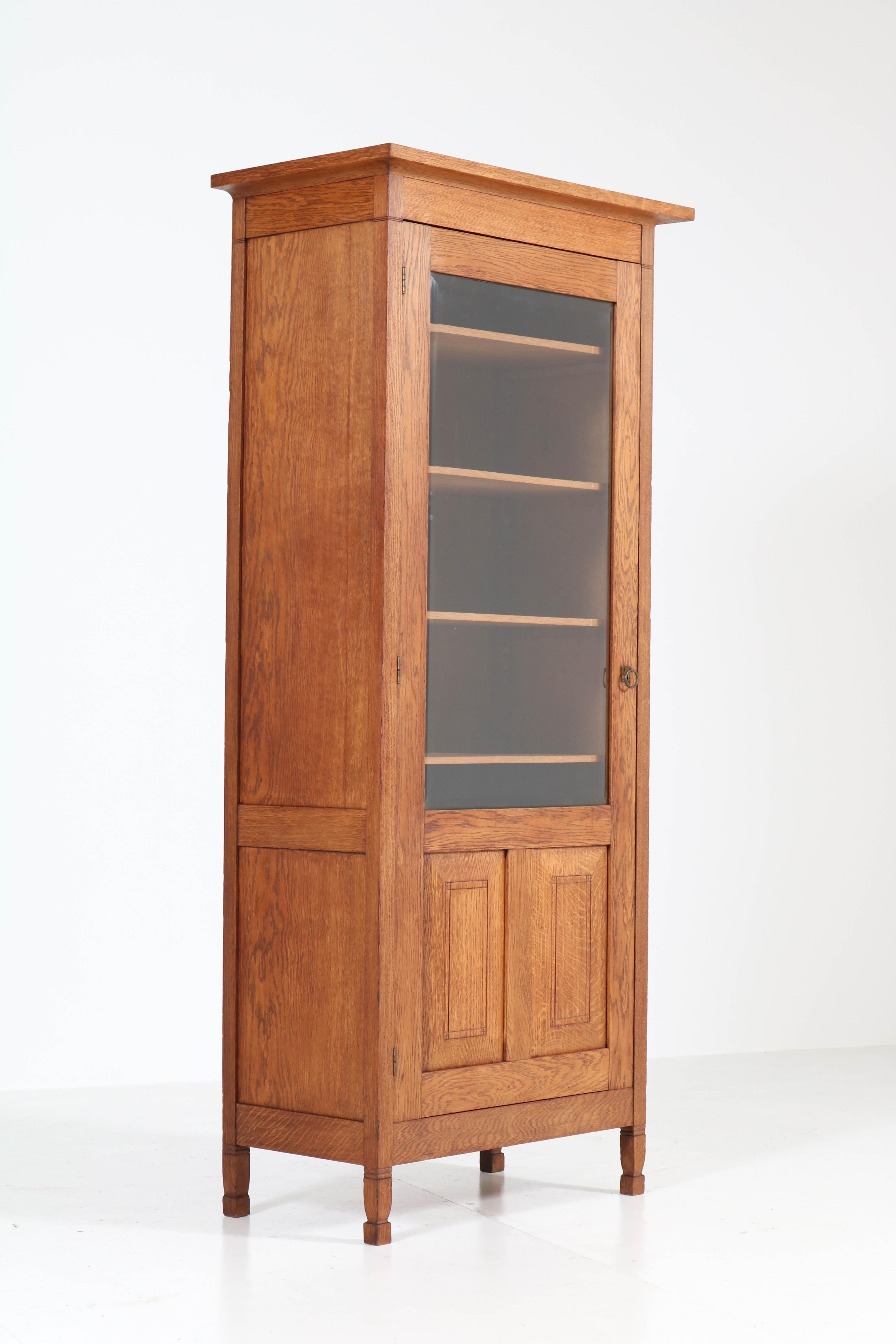 Wonderful and rare Art Nouveau Arts & Crafts bookcase.
Design by Willem Penaat.
Striking Dutch design from the 1900s.
Solid oak with original beveled glass and original brass handle.
Five original solid oak shelves, adjustable in height.
This