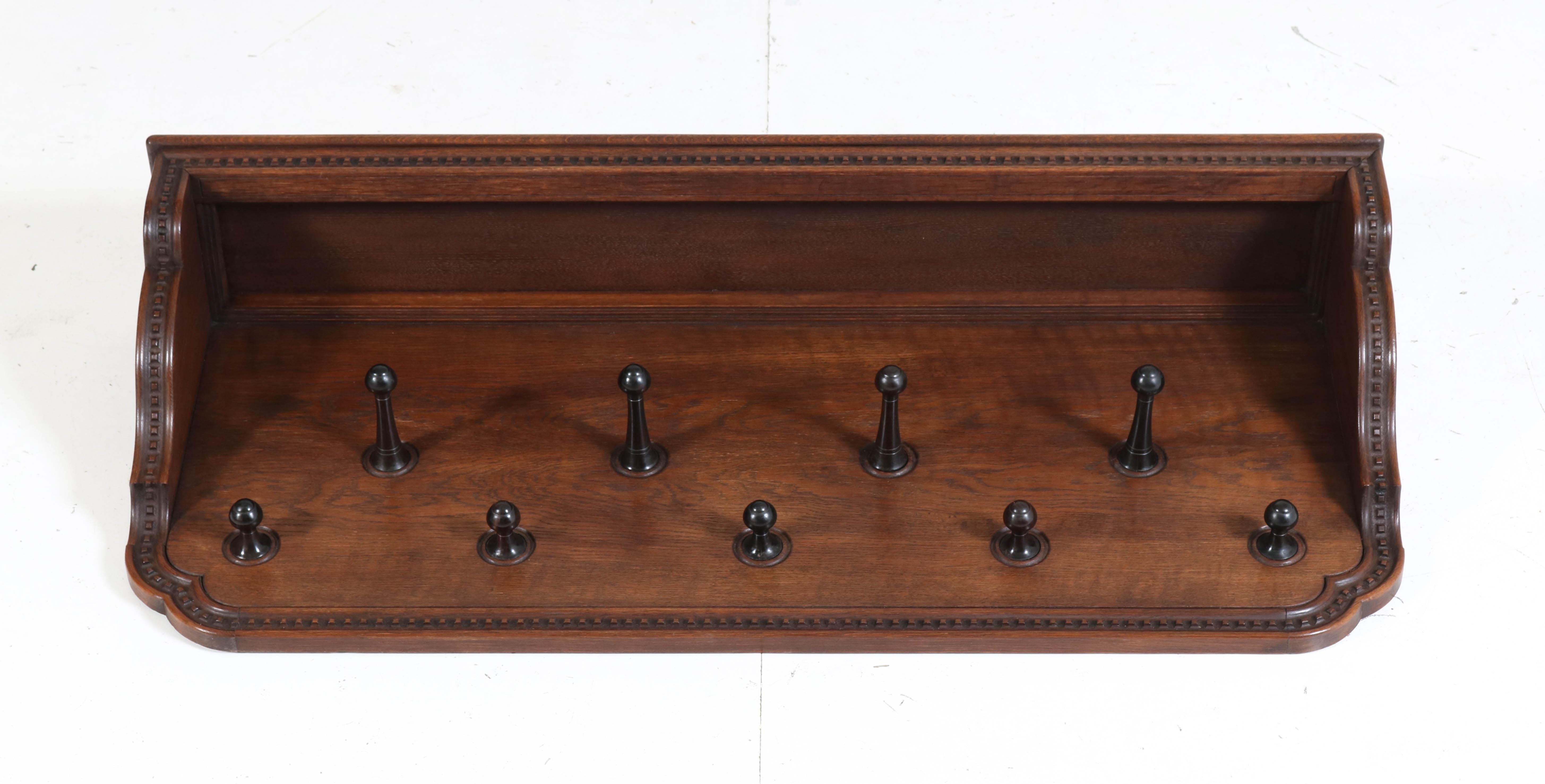 Magnificent and rare Art Nouveau Arts & Crafts coat rack.
Design by K.P.C. de Bazel.
Striking Dutch design from the 1900s.
Solid oak and oak veneer with original solid ebony hooks.
In good original condition with minor wear consistent with age