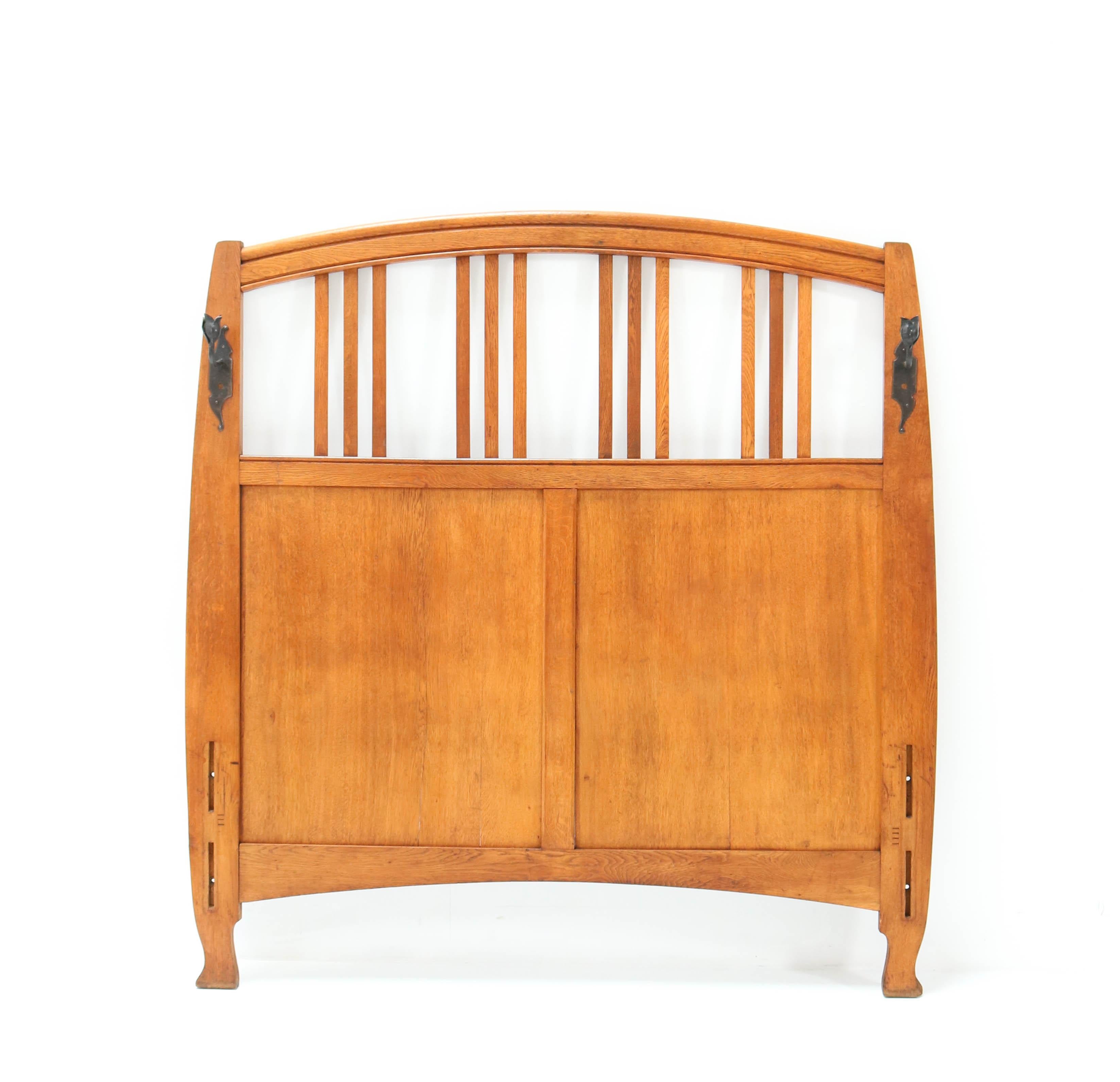 Magnifique et rare lit double Art Nouveau Arts & Crafts.
Design de Gustave Serrurier-Bovy.
Un design belge saisissant des années 1900.
Chêne massif avec une paire de bougeoirs d'origine en fer forgé laqué noir.
En bon état d'origine avec une