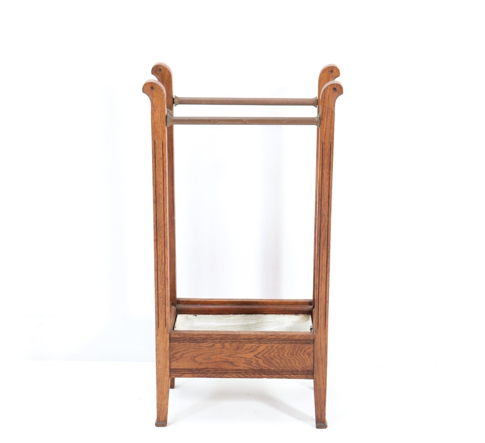 Stunning and rare Art Nouveau Arts & Crafts umbrella stand.
Striking Dutch design from the 1900s.
Solid oak frame with original patinated brass bars for holding
the umbrellas.
Original patinated sink reservoir.
In very good condition with a